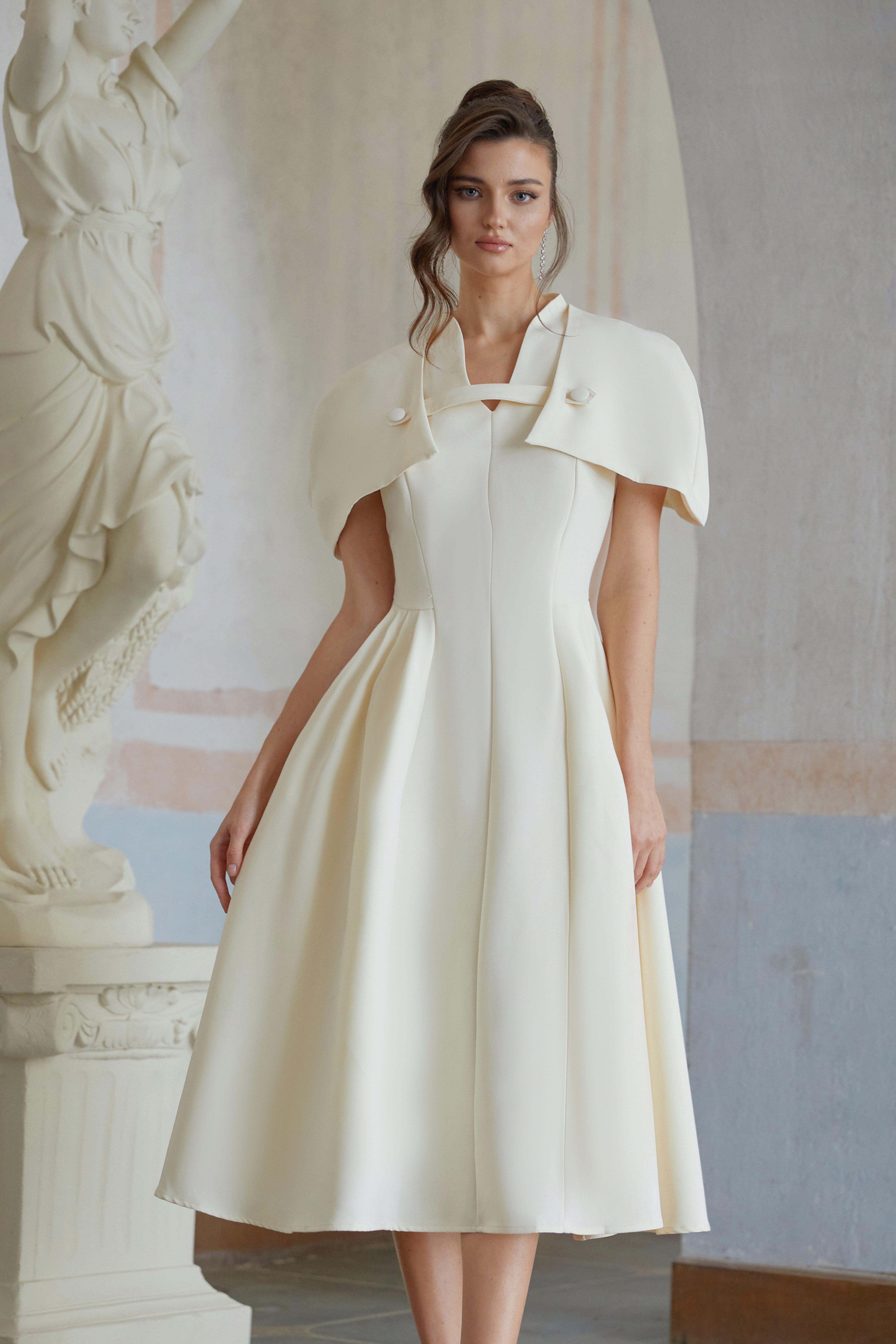 Cream midi dress with a structured capelet overlay and button details
