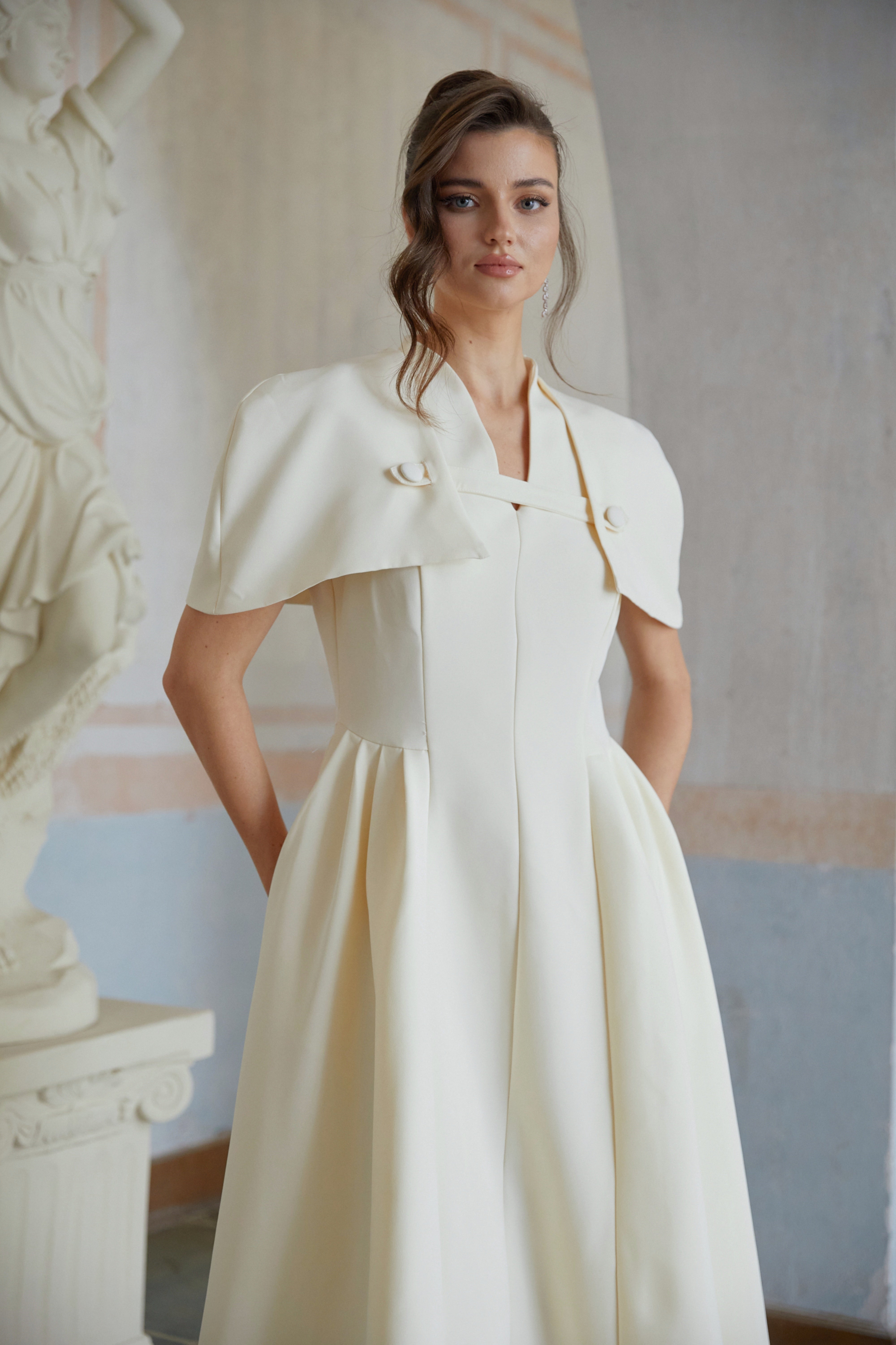Cream midi dress with a structured capelet overlay and button details