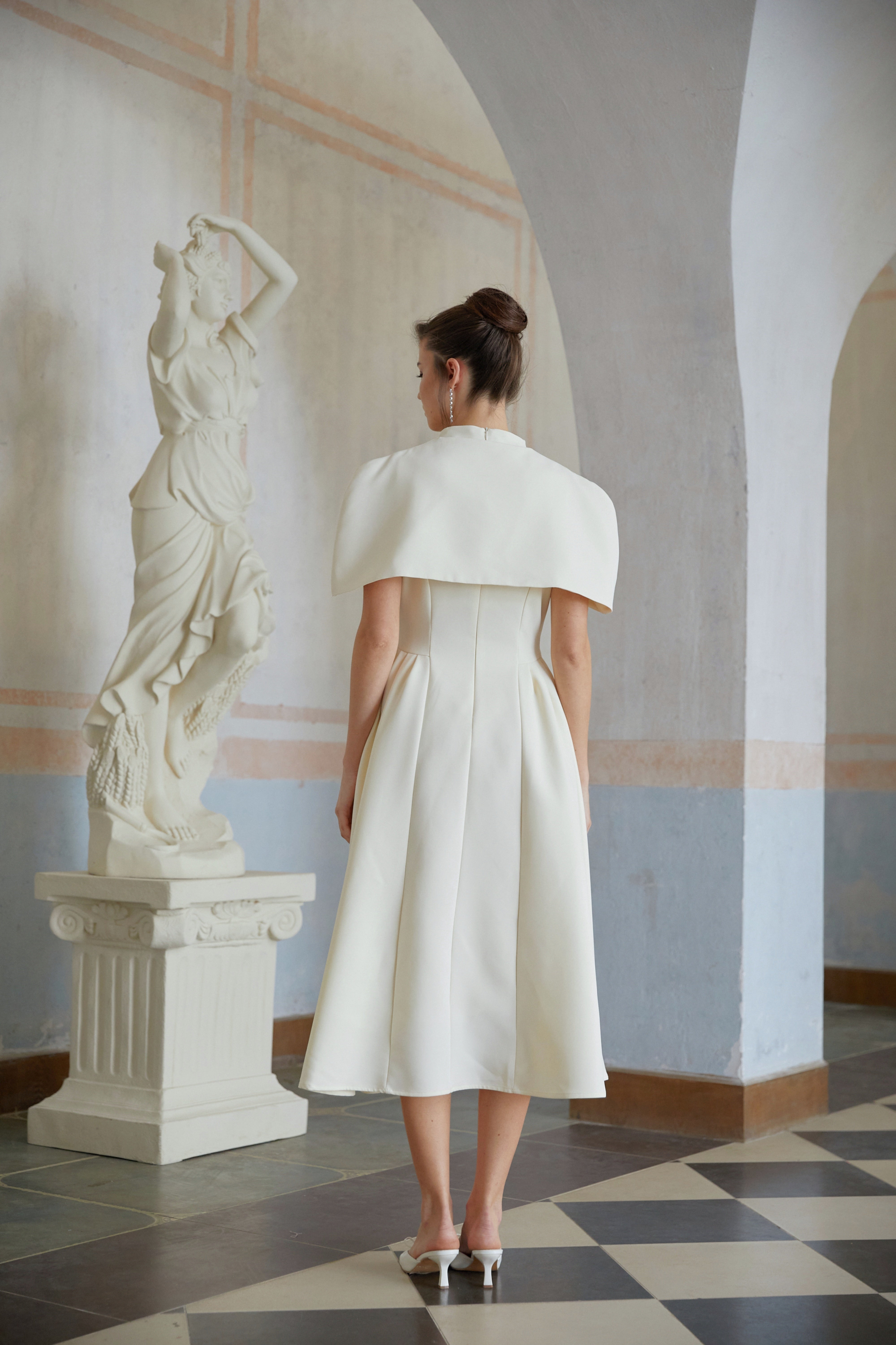 Cream midi dress with a structured capelet overlay and button details