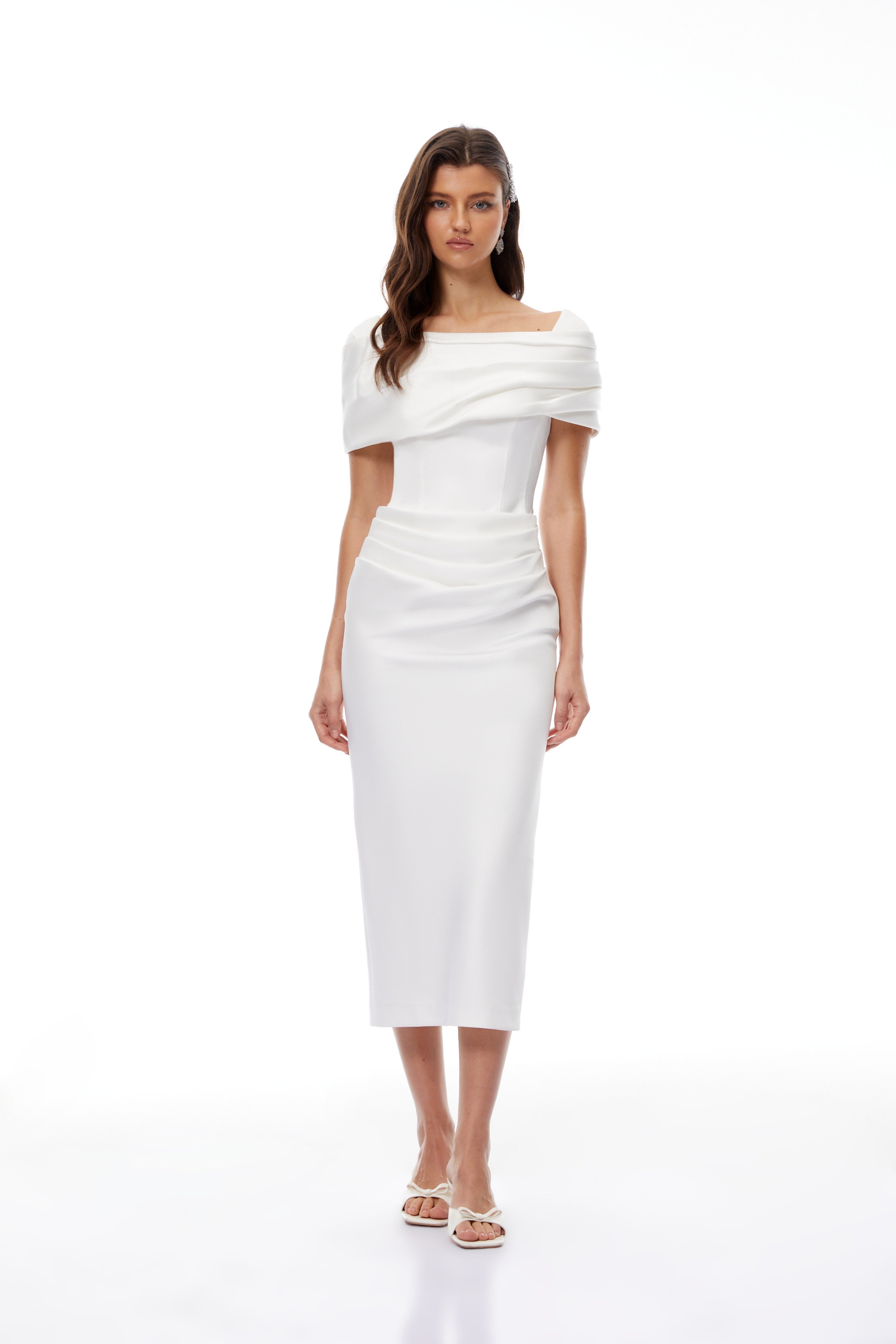 White off-the-shoulder gown with a draped bodice and cascading side ruffles