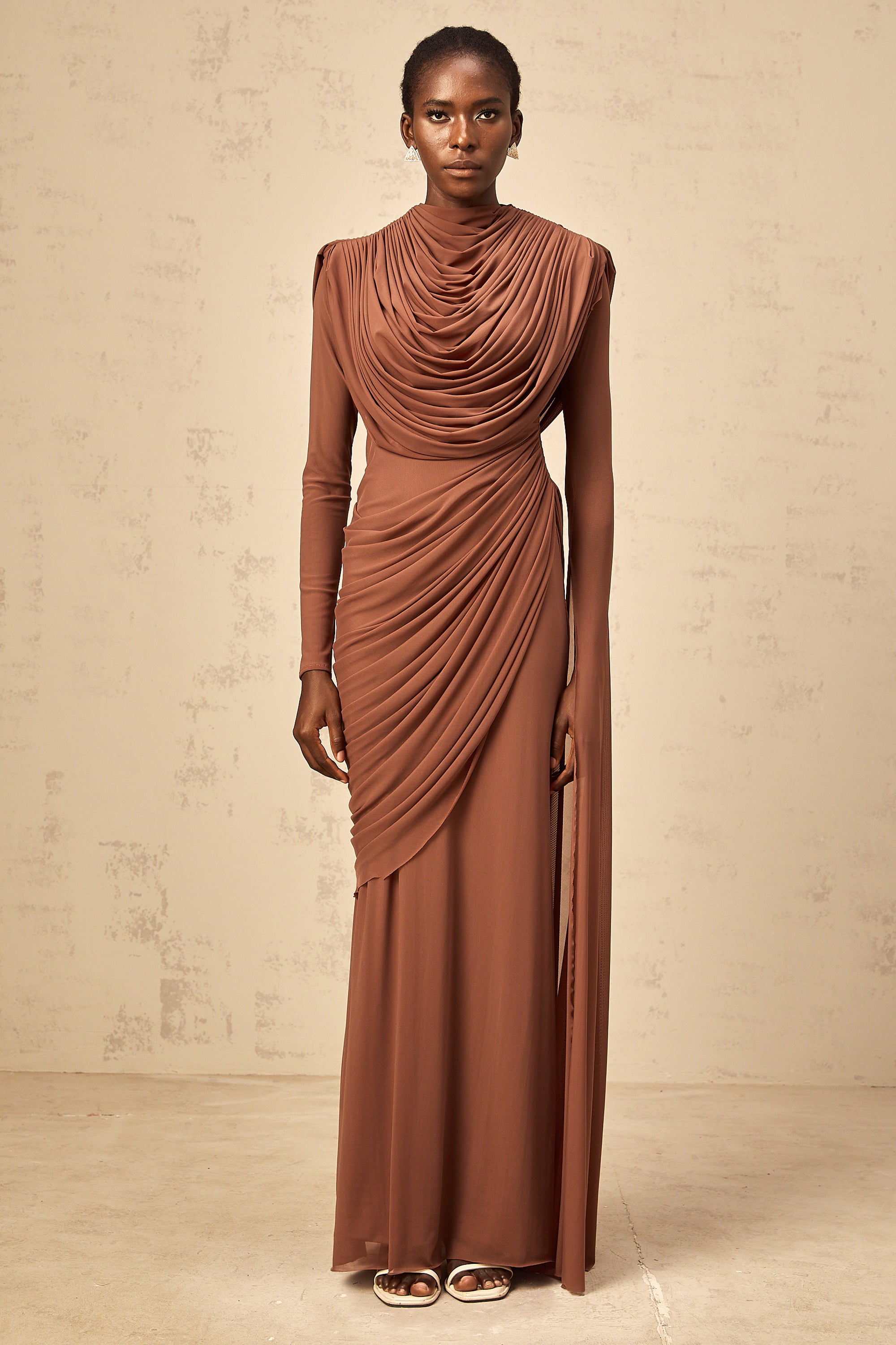 Rust-colored long-sleeve maxi dress with a draped cowl neckline and pleated bodice