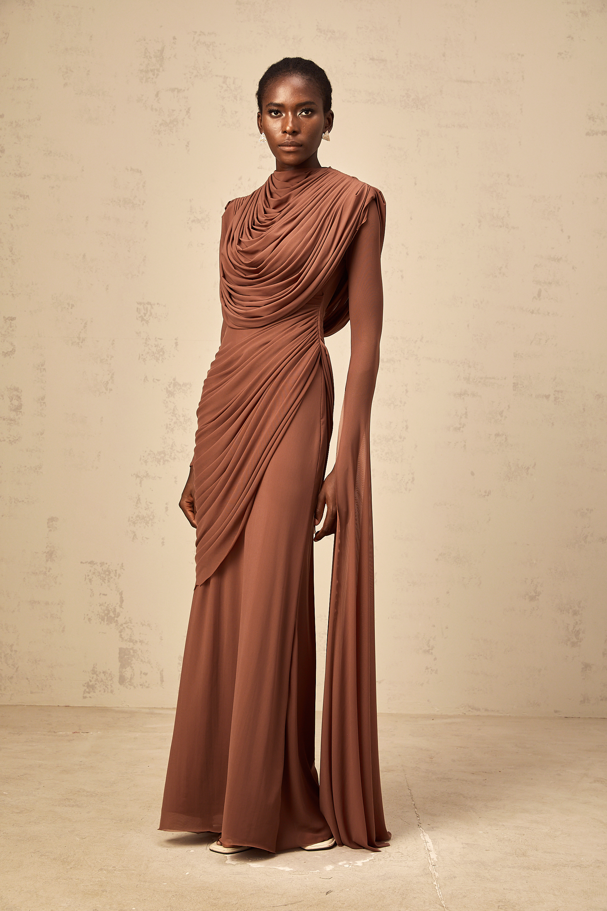 Rust-colored long-sleeve maxi dress with a draped cowl neckline and pleated bodice