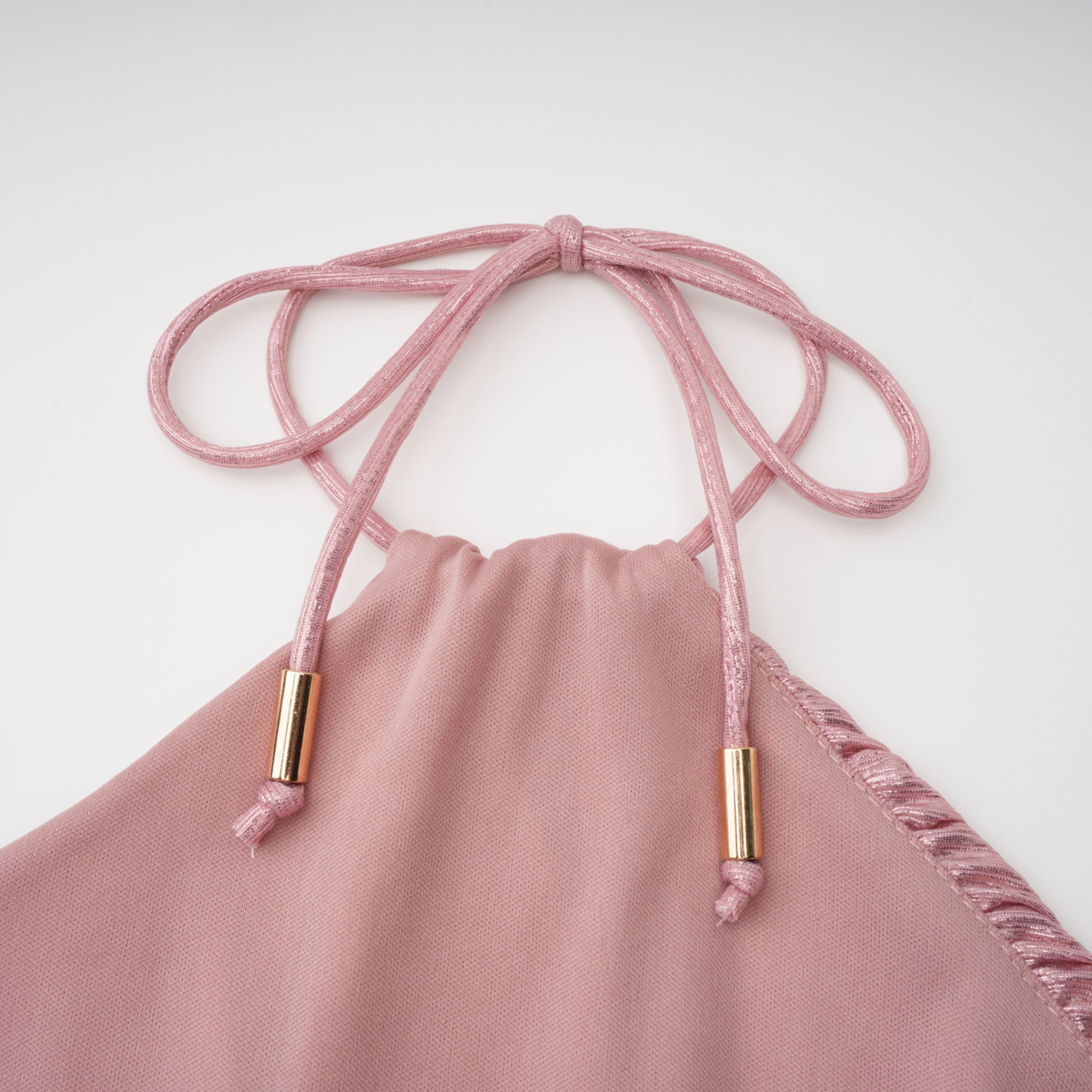 Metallic rose pink pleat halter gown with a cinched waist and high leg slit