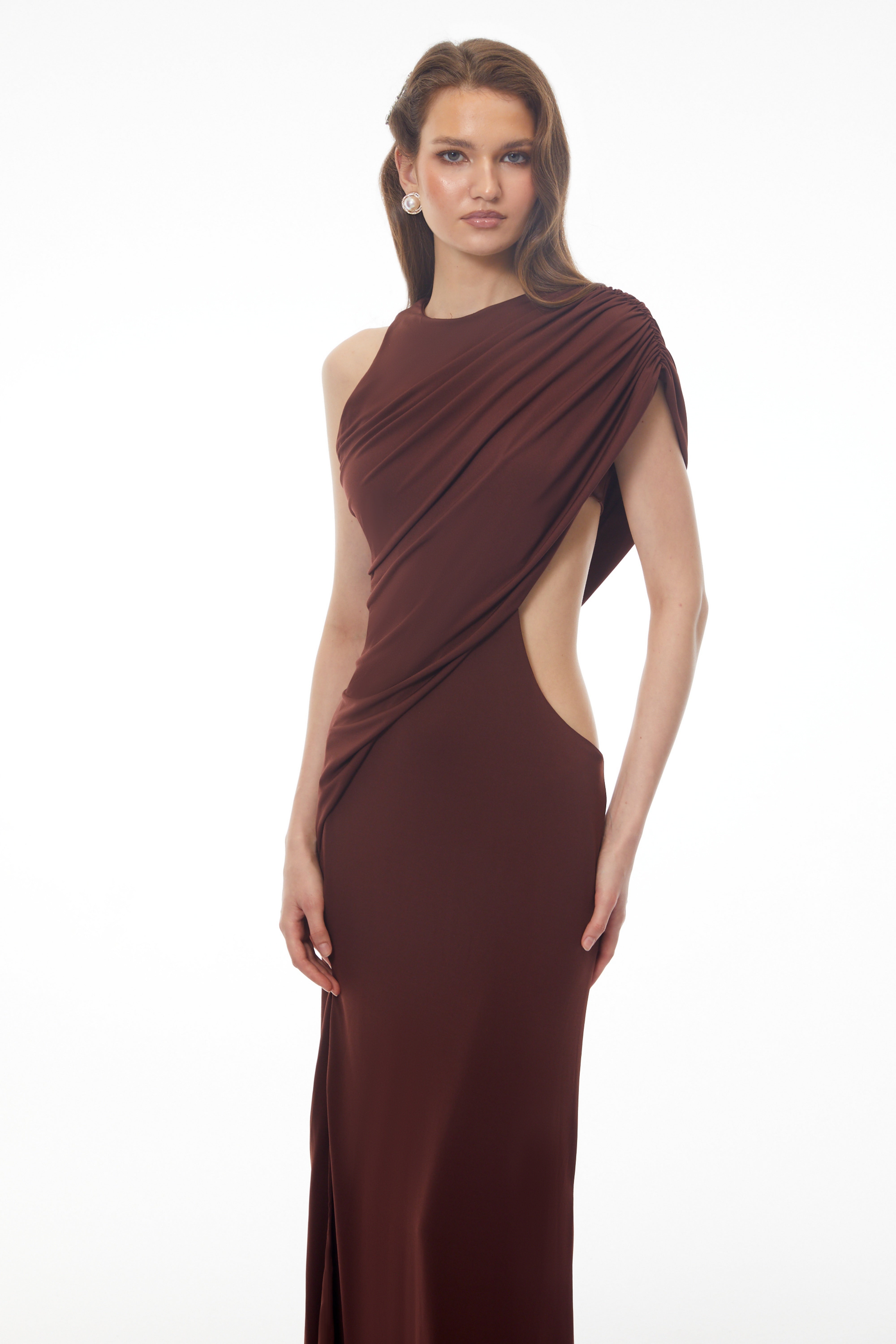 Dark brown maxi dress featuring a one-shoulder neckline, asymmetric draped overlay, and a high front slit