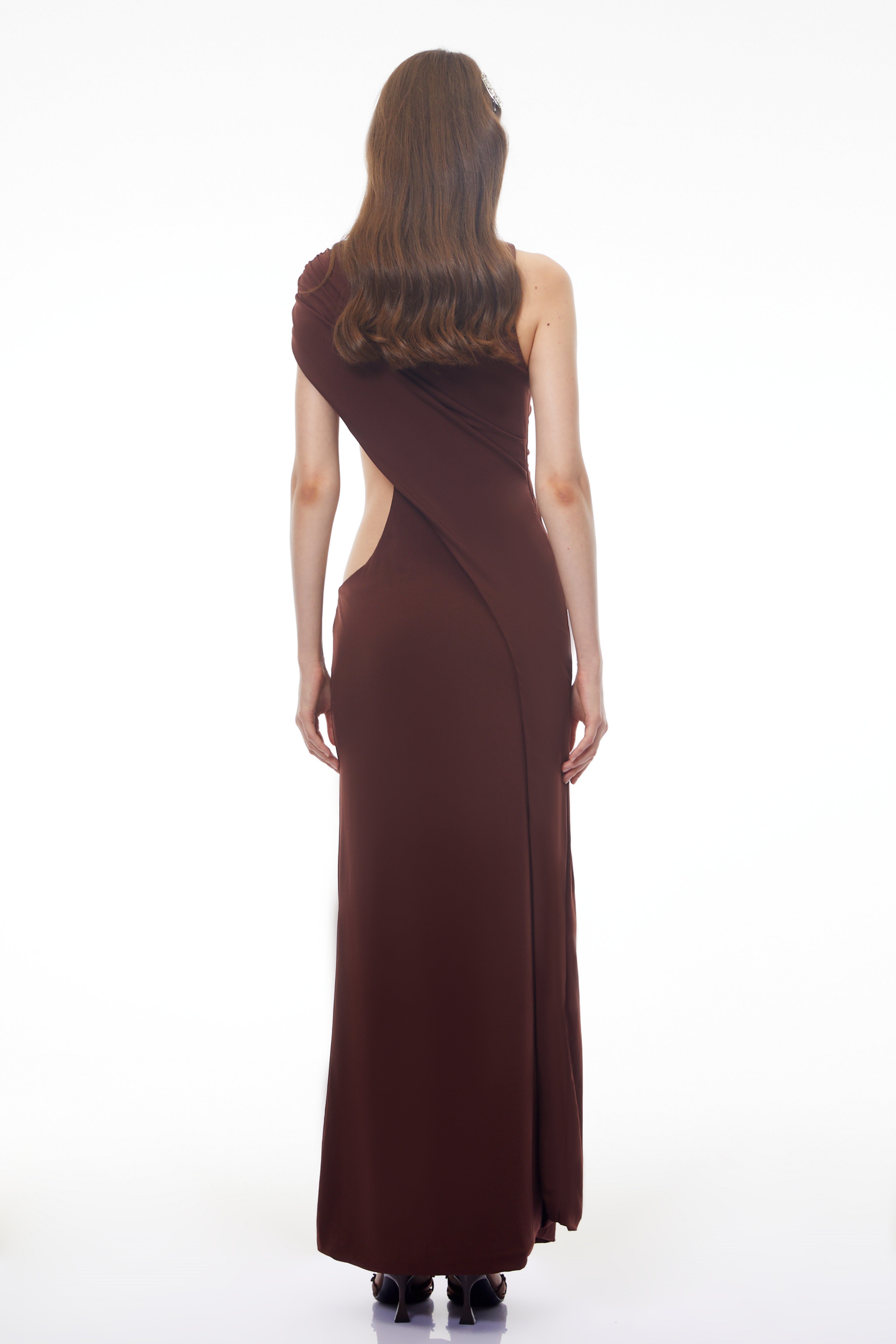 Dark brown maxi dress featuring a one-shoulder neckline, asymmetric draped overlay, and a high front slit
