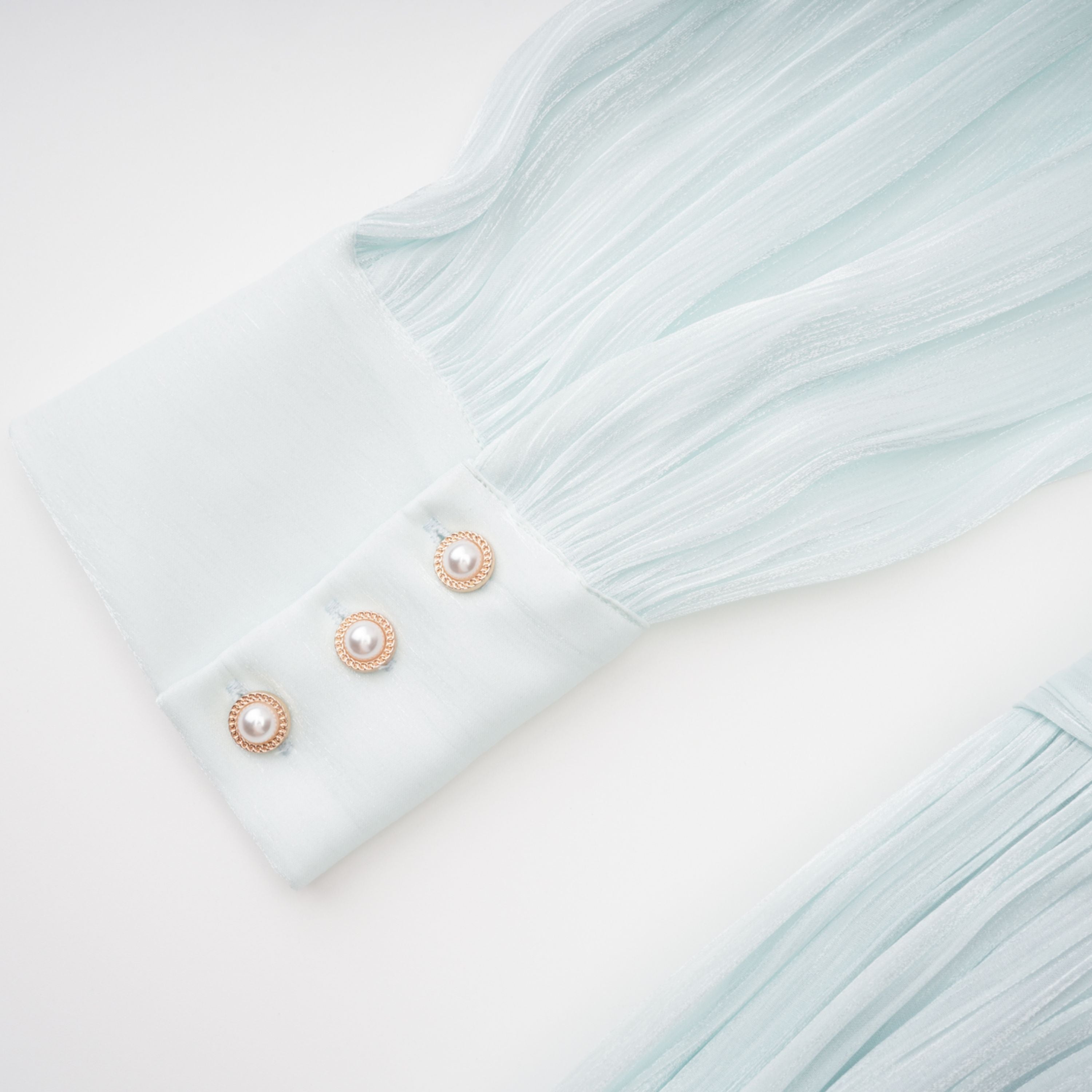 Light green maxi dress with a ruched bodice, round neckline, and long sheer sleeves