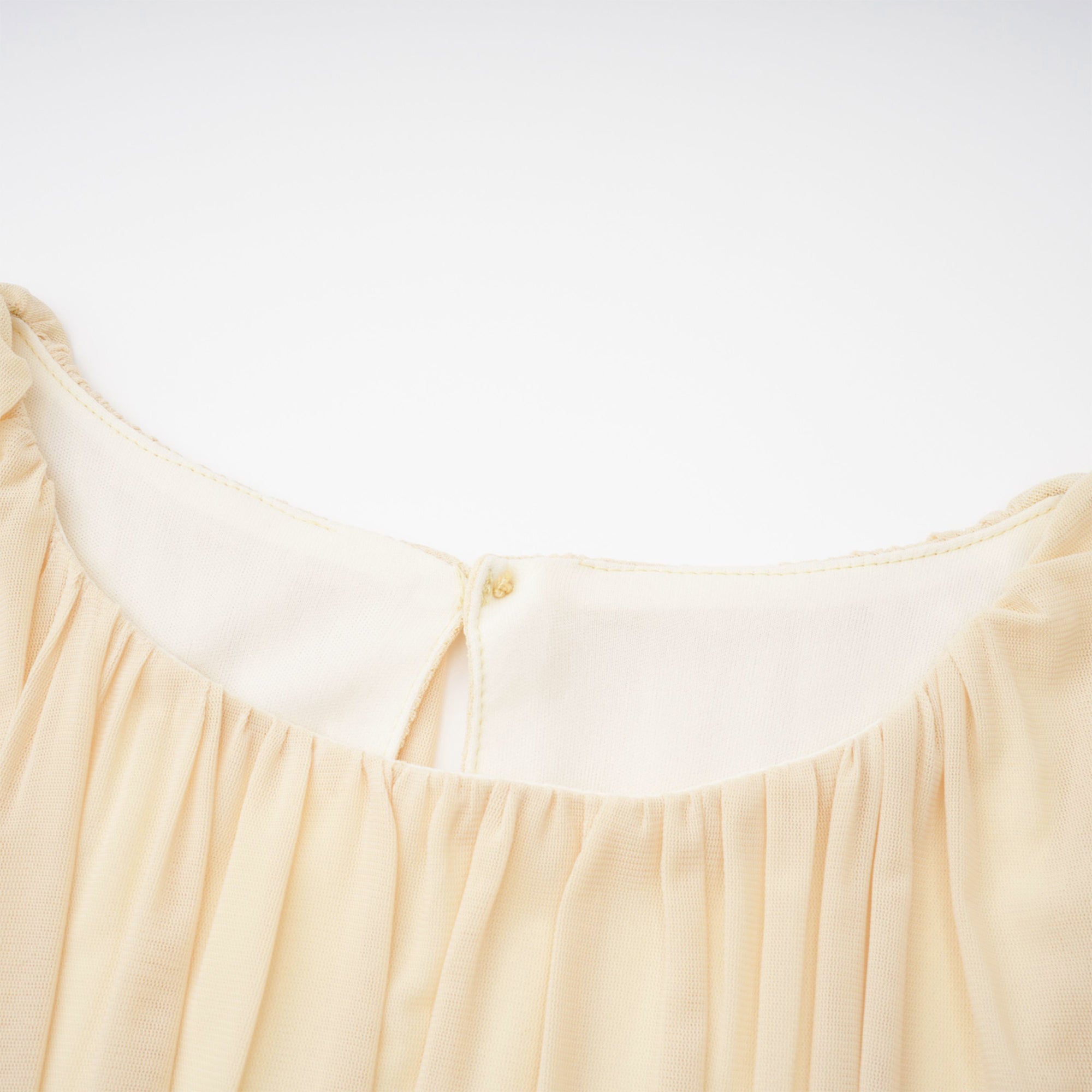 Pale yellow maxi dress with a ruched bodice, high round neckline, and long bishop sleeves