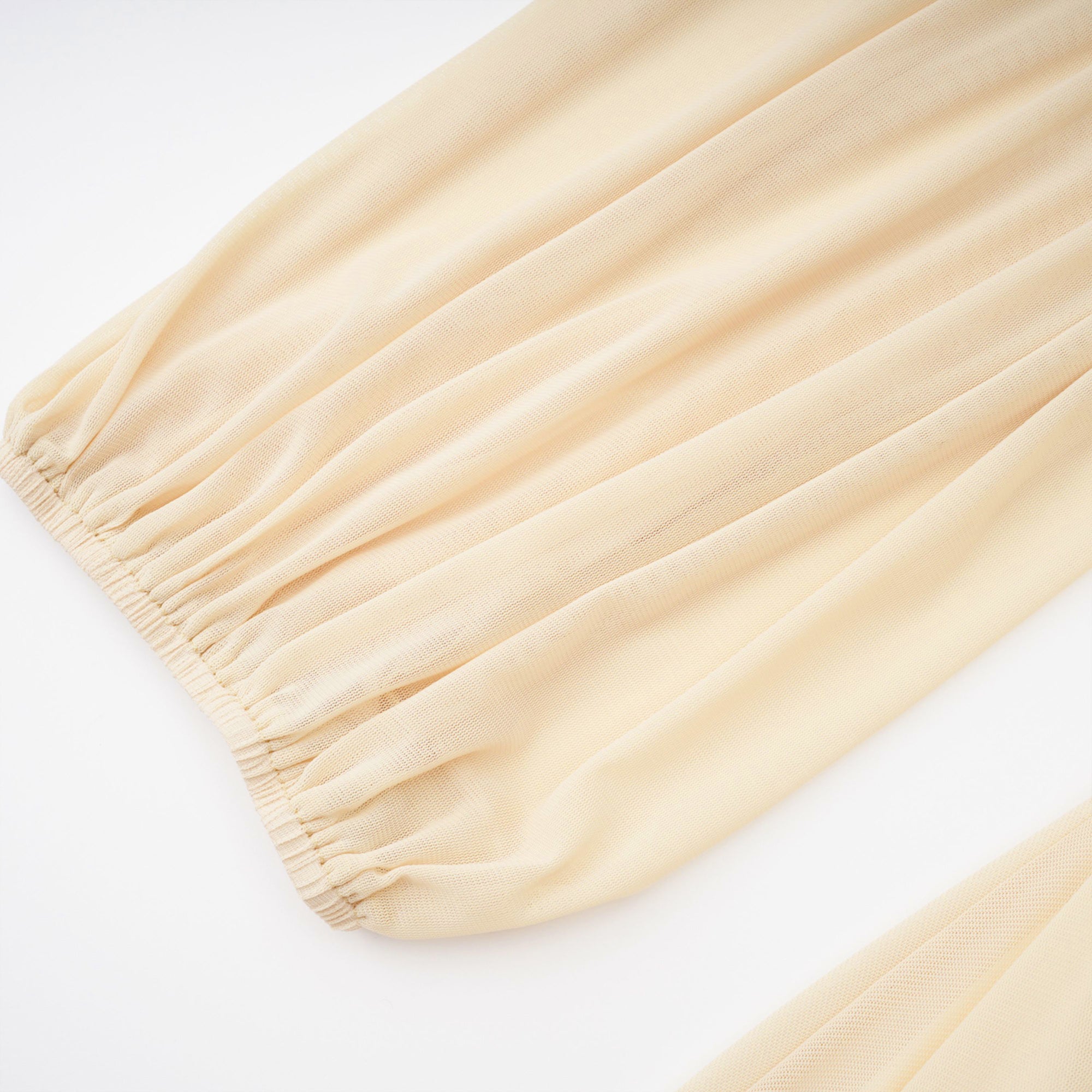 Pale yellow maxi dress with a ruched bodice, high round neckline, and long bishop sleeves