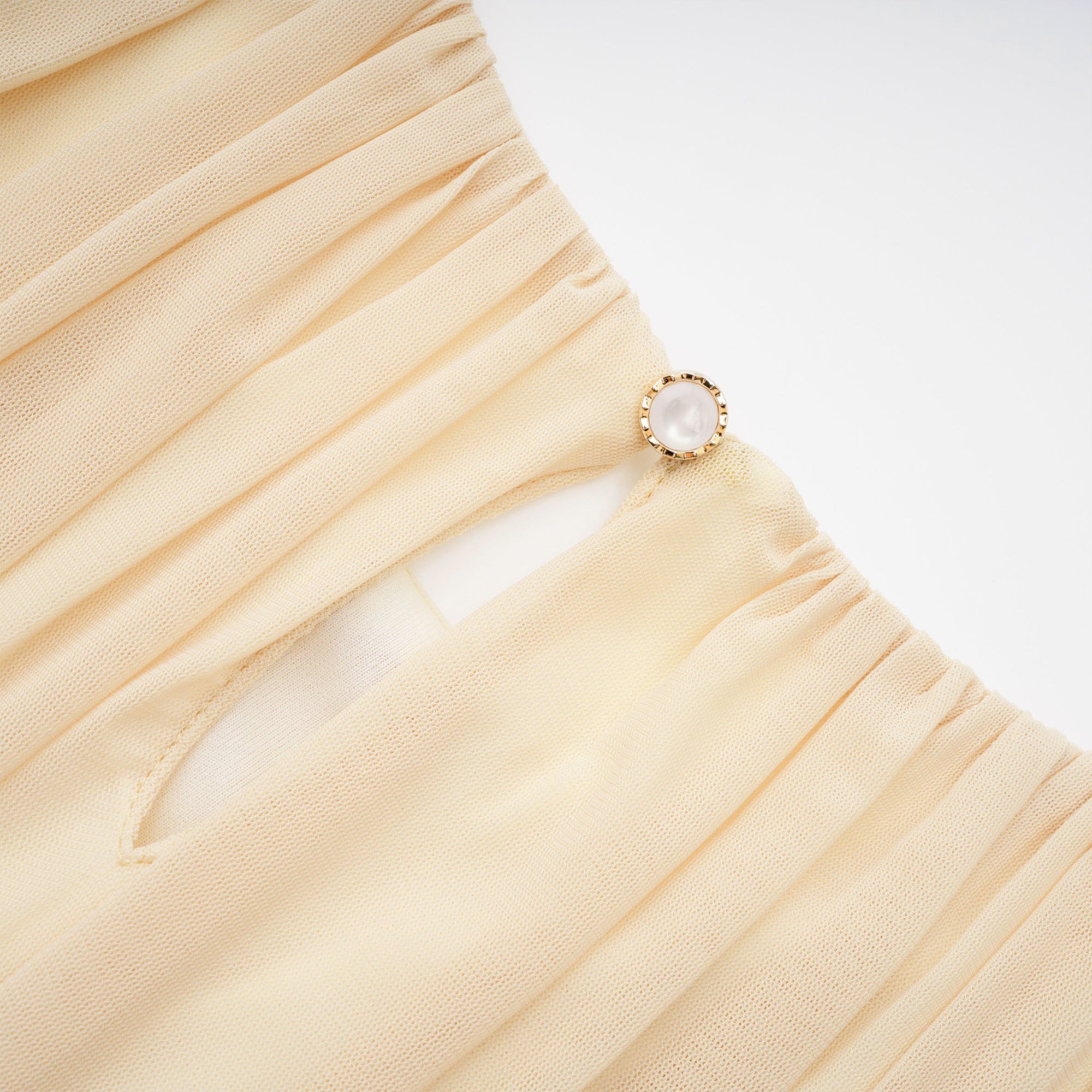 Pale yellow maxi dress with a ruched bodice, high round neckline, and long bishop sleeves