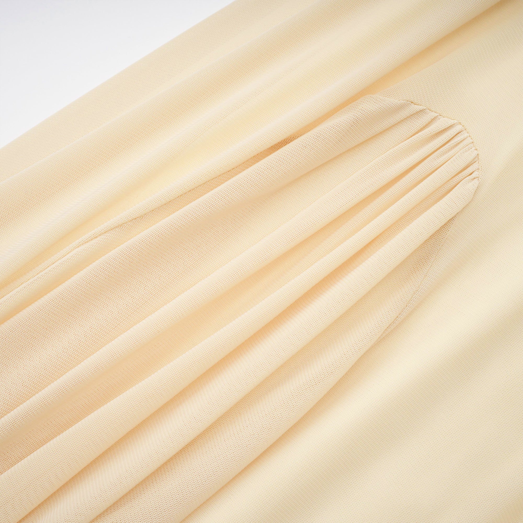 Pale yellow maxi dress with a ruched bodice, high round neckline, and long bishop sleeves