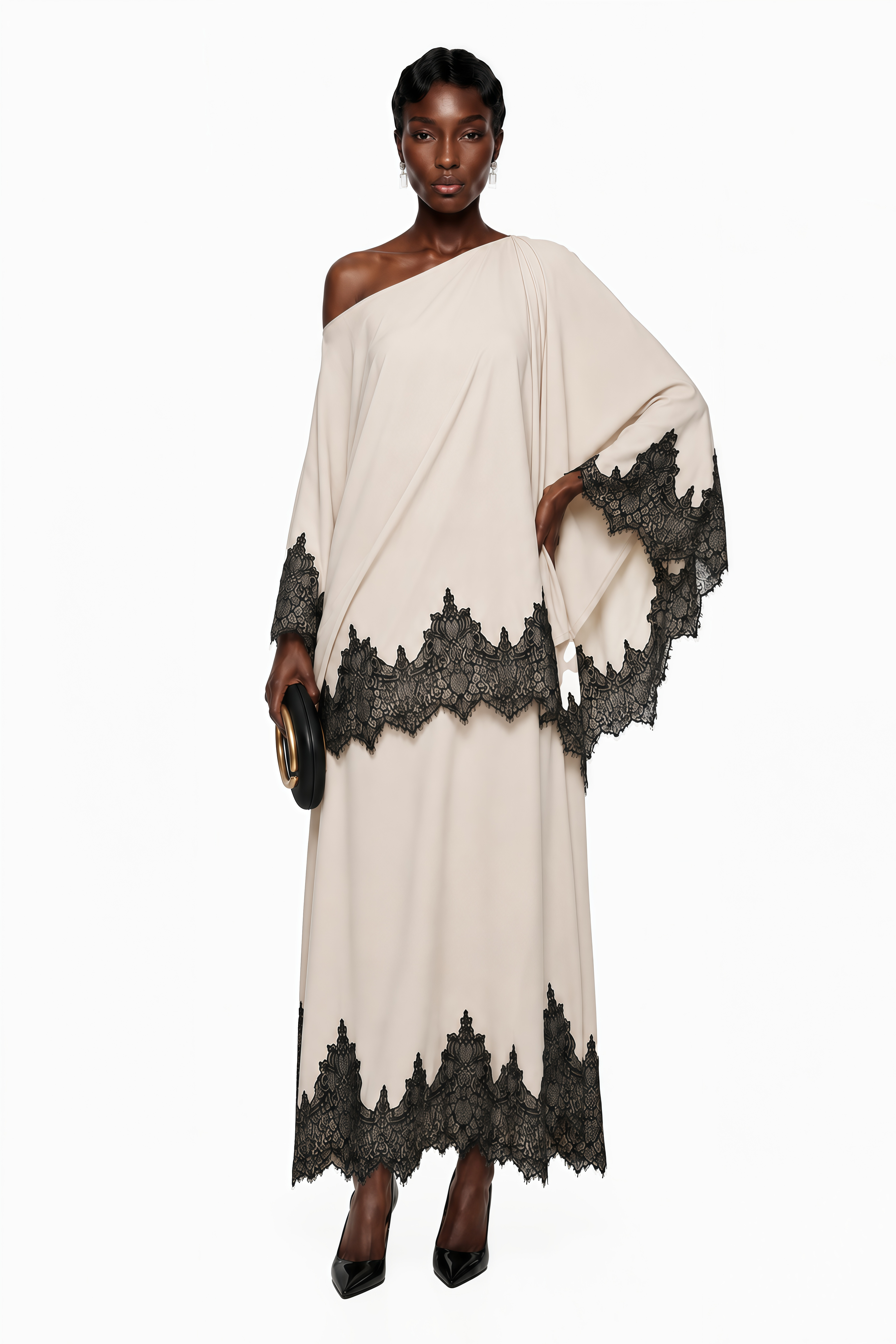 Cream one-shoulder maxi dress with an asymmetric black lace-trimmed cape and black lace-trimmed hem