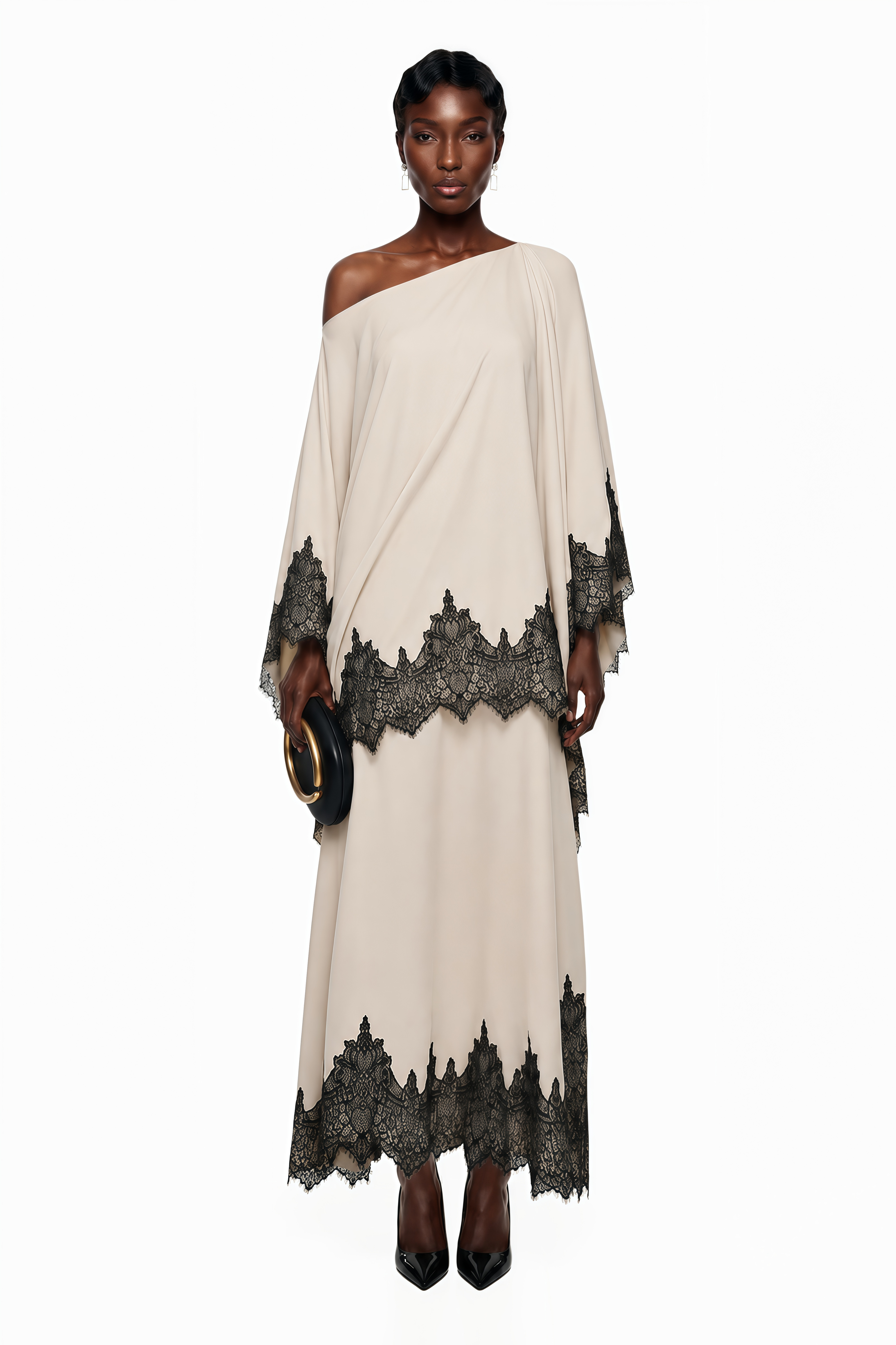 Cream one-shoulder maxi dress with an asymmetric black lace-trimmed cape and black lace-trimmed hem