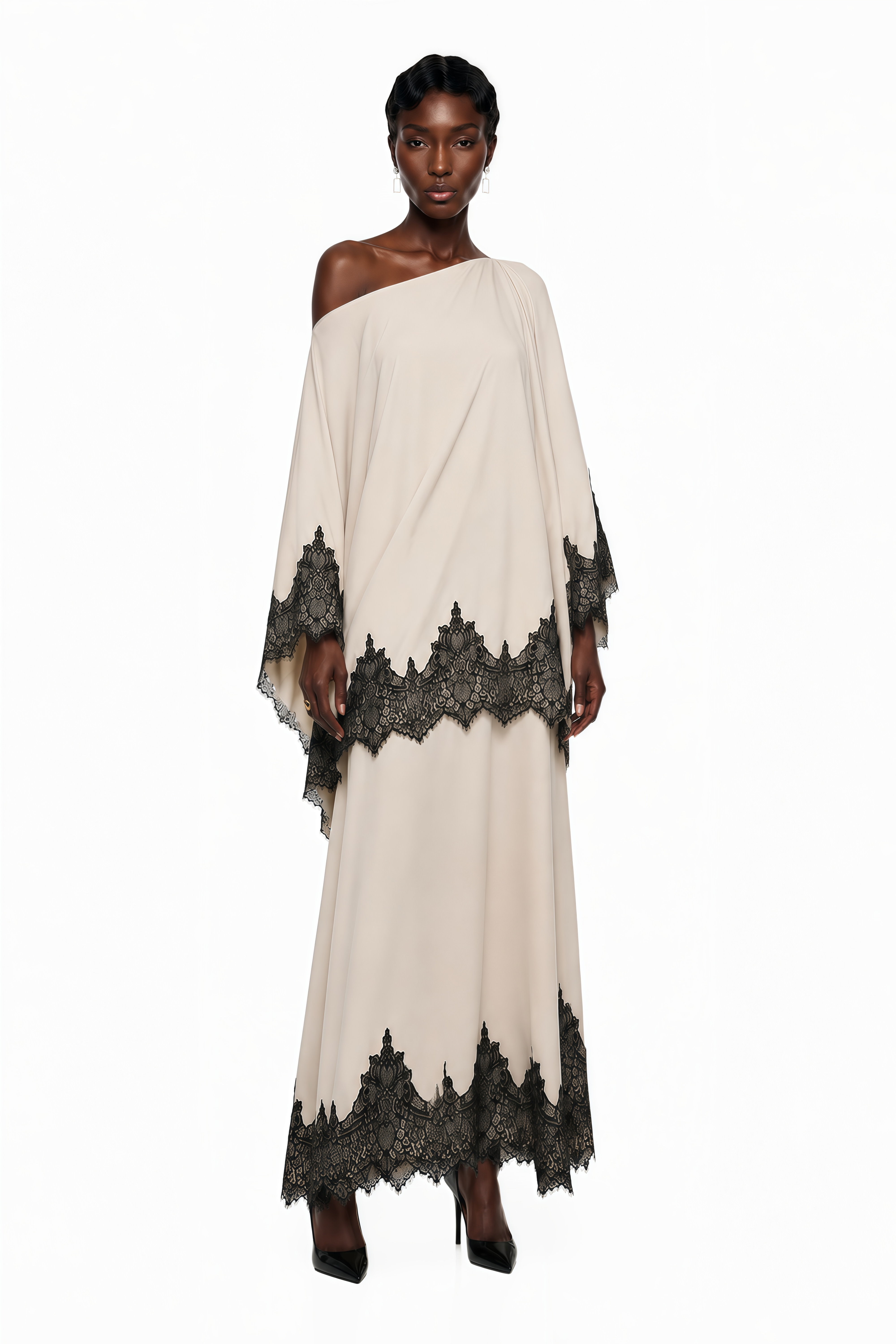 Cream one-shoulder maxi dress with an asymmetric black lace-trimmed cape and black lace-trimmed hem