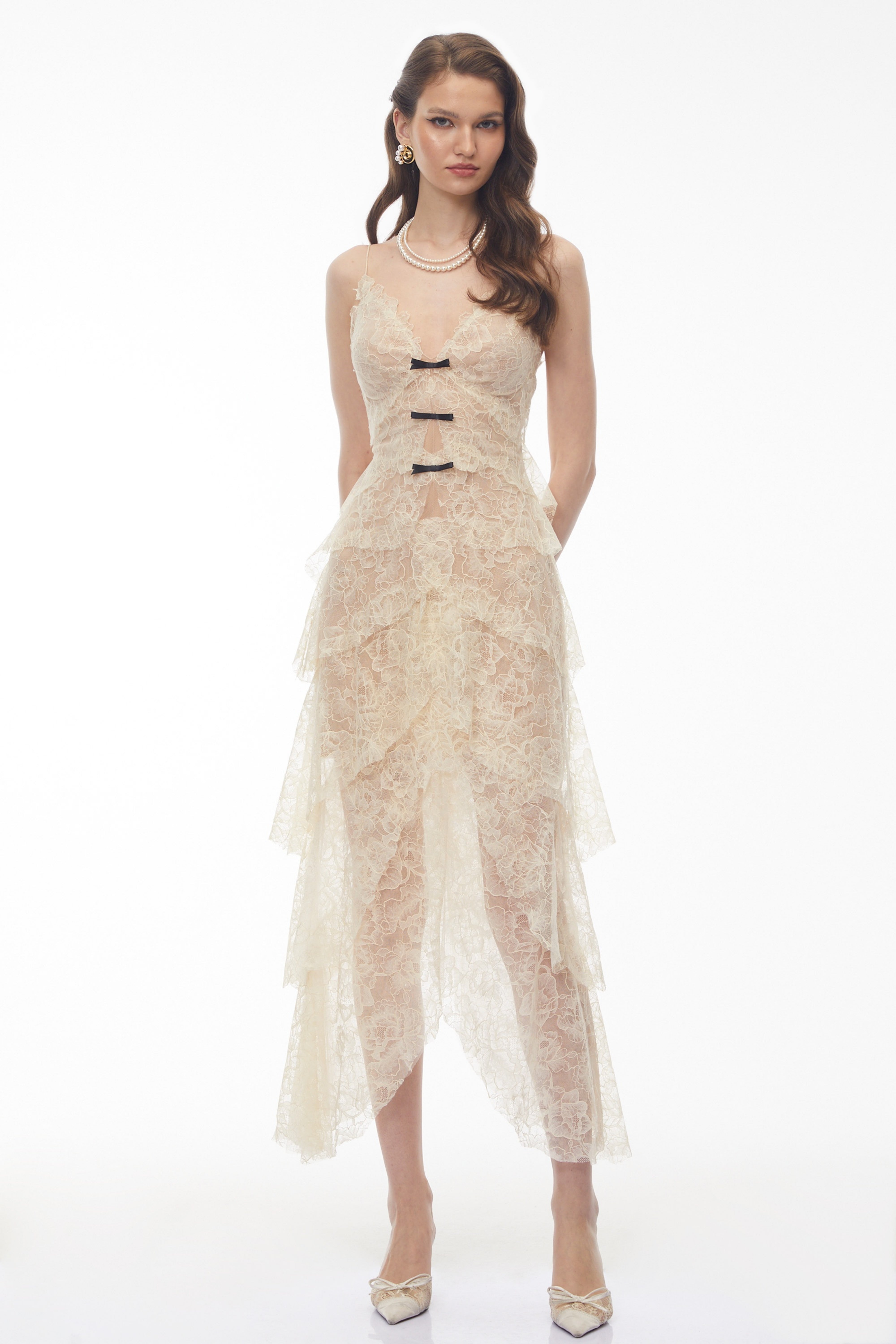 Cream tiered lace maxi dress with small black bow accents