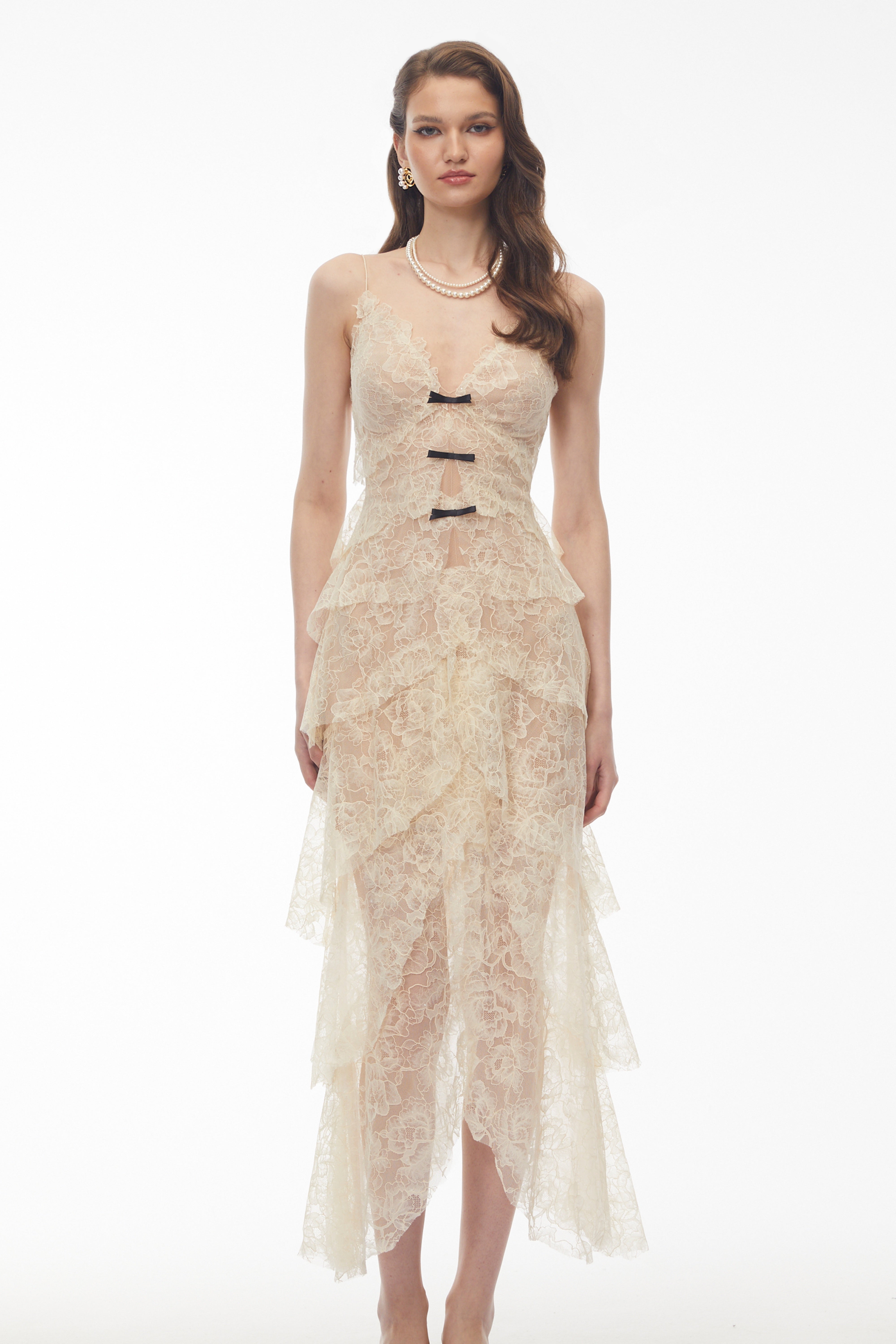 Cream tiered lace maxi dress with small black bow accents
