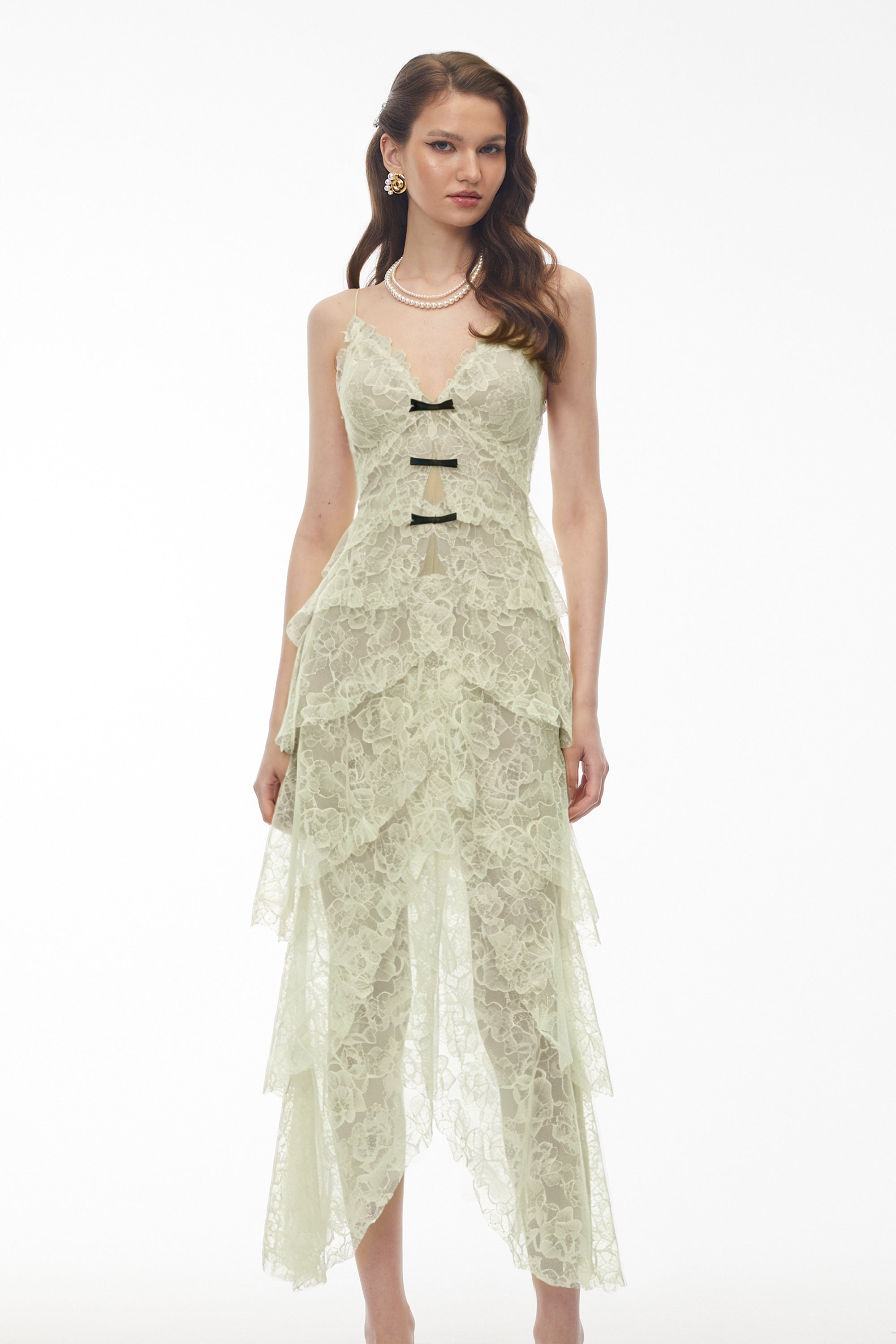 Sage green tiered lace dress with black bow accents