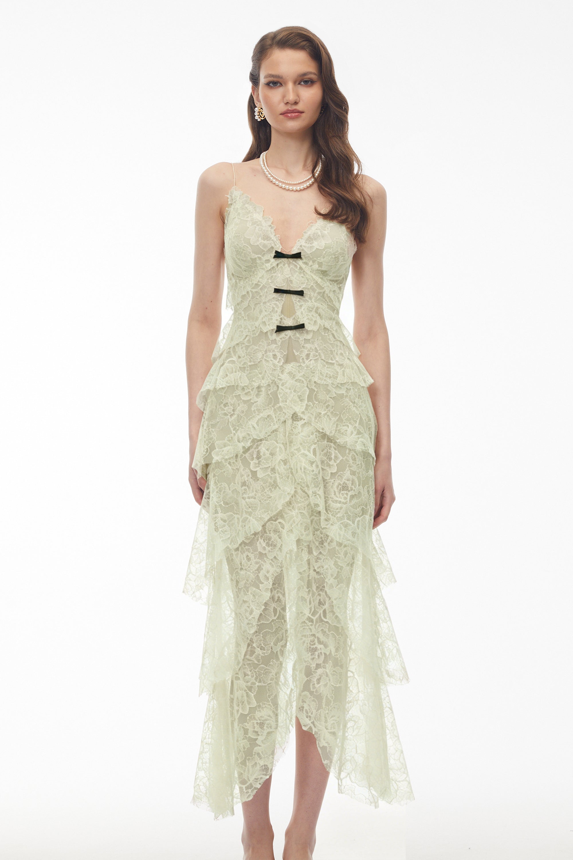 Sage green tiered lace dress with black bow accents