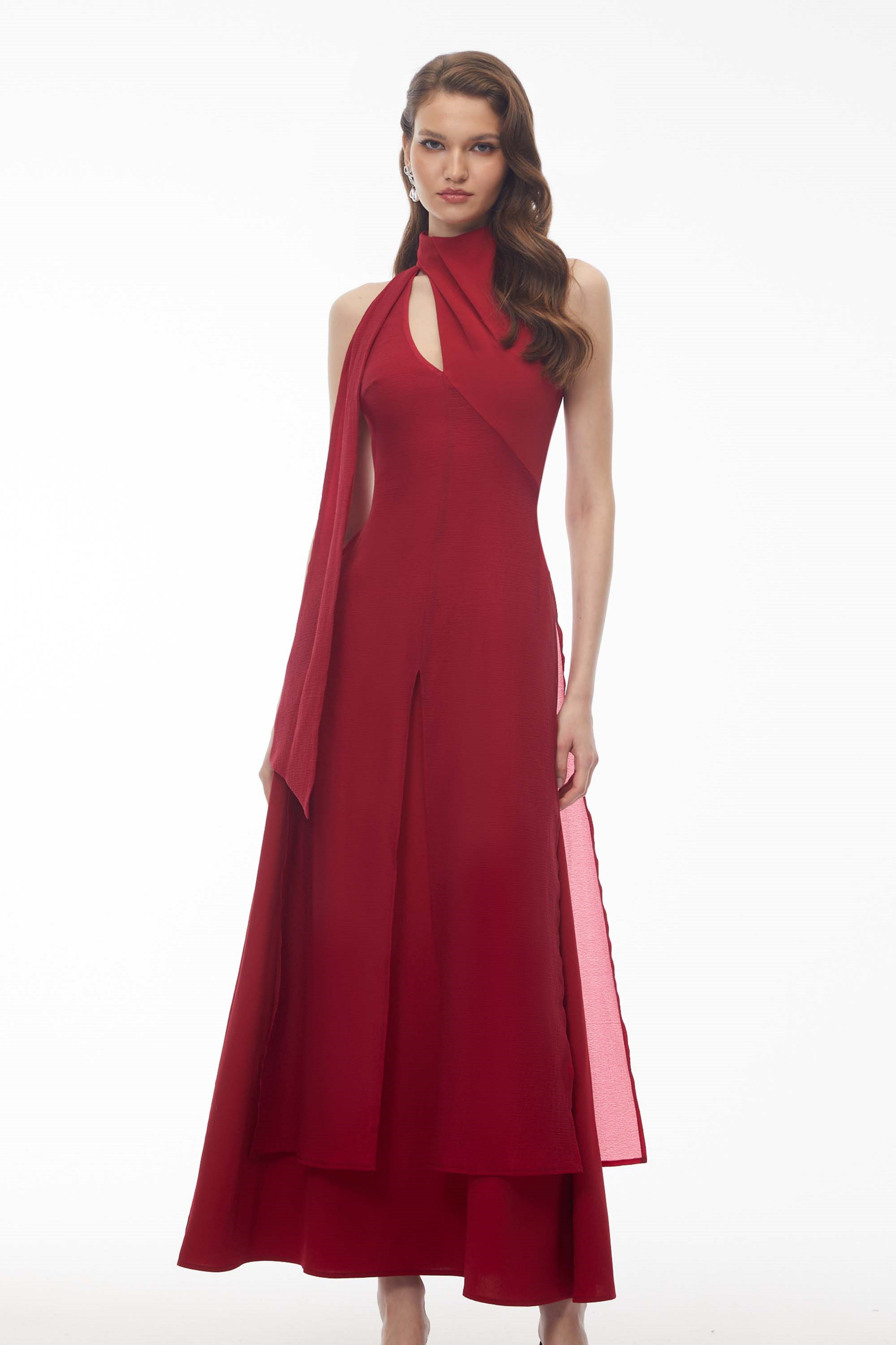 Red maxi dress with a high halter neckline, an asymmetrical cutout, and a long draped scarf detail