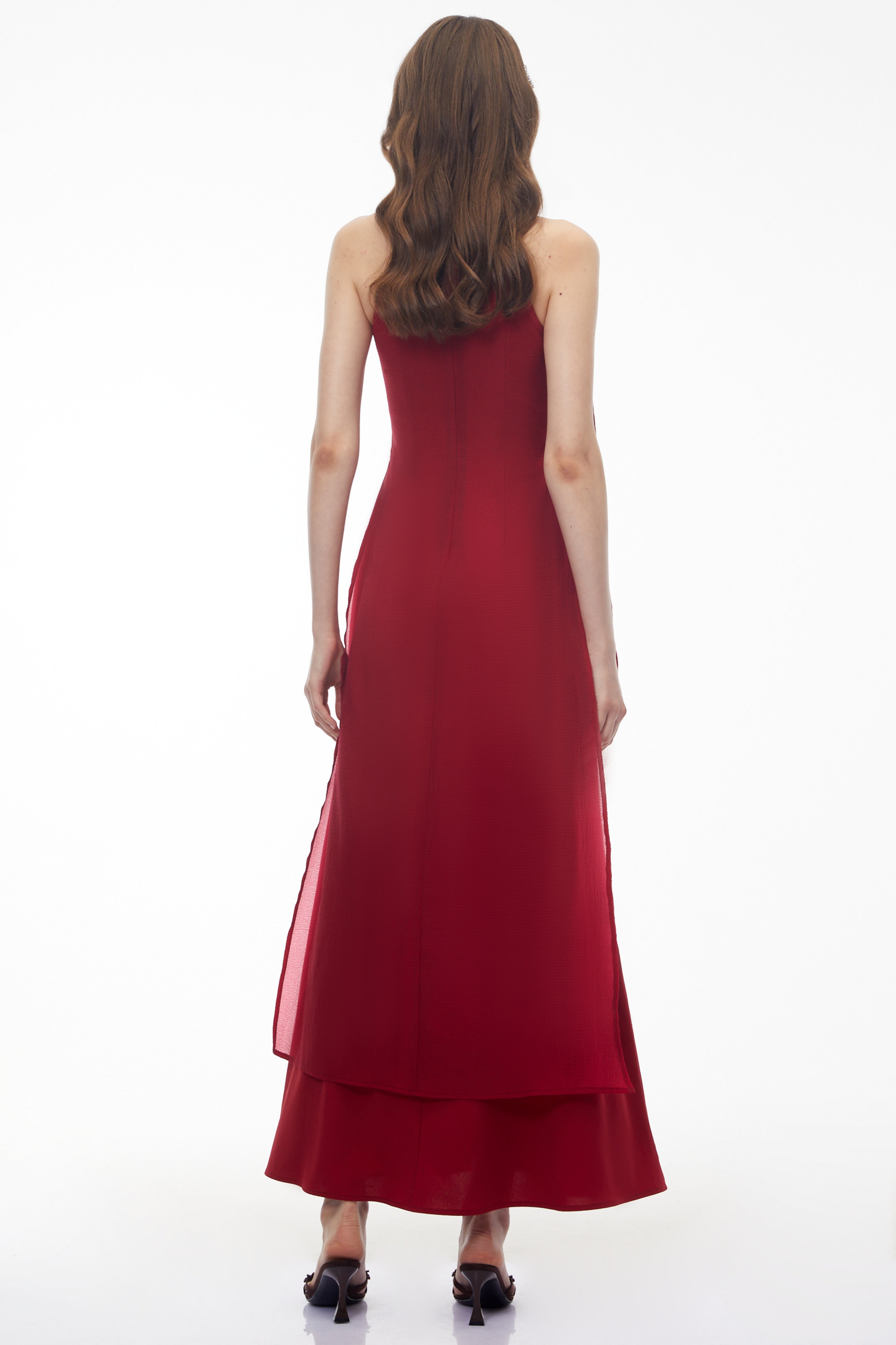 Red maxi dress with a high halter neckline, an asymmetrical cutout, and a long draped scarf detail