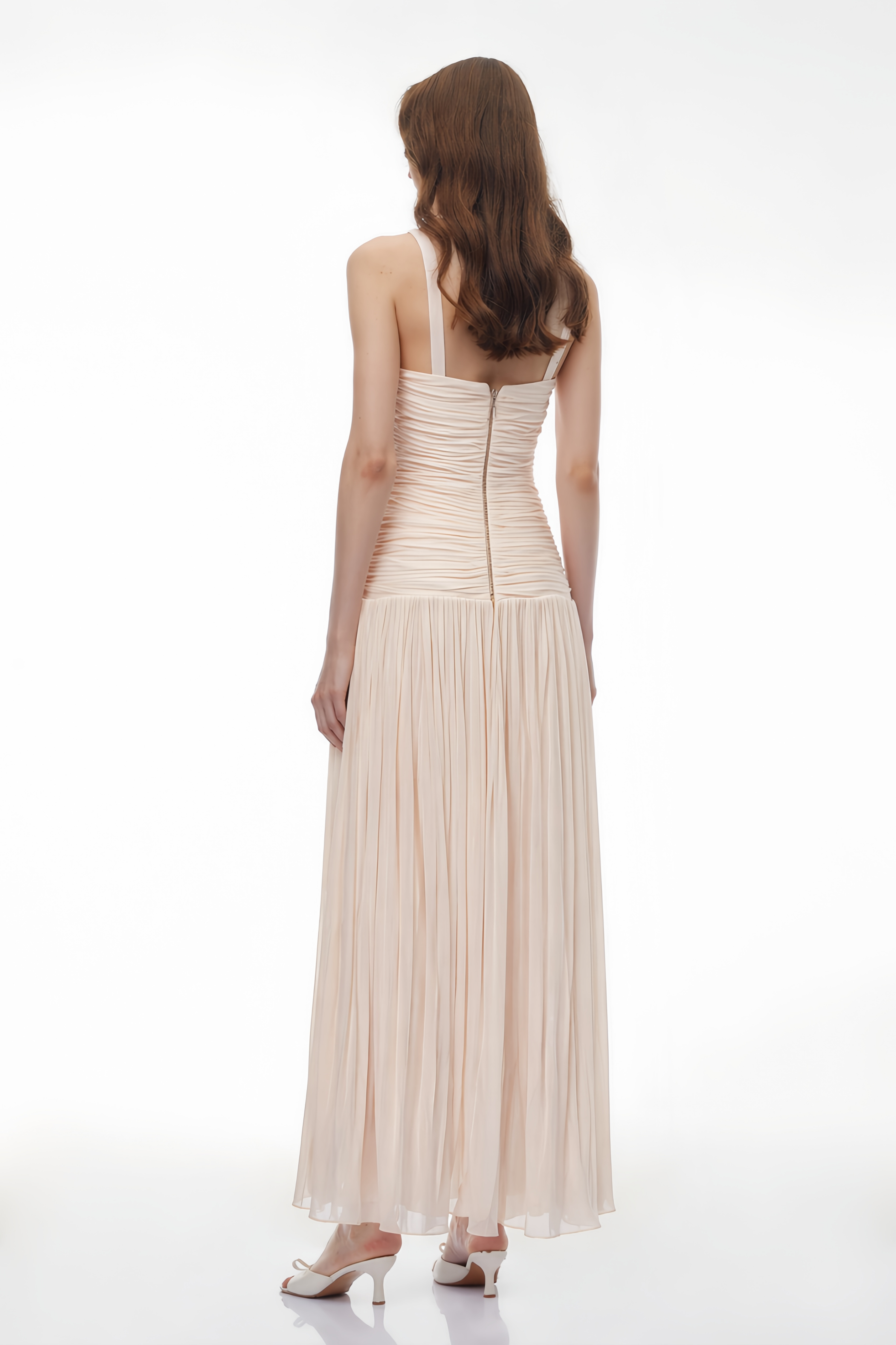 Light pink maxi dress featuring a sheer white lace corset bodice, a draped twist waistband, and a finely pleated skirt