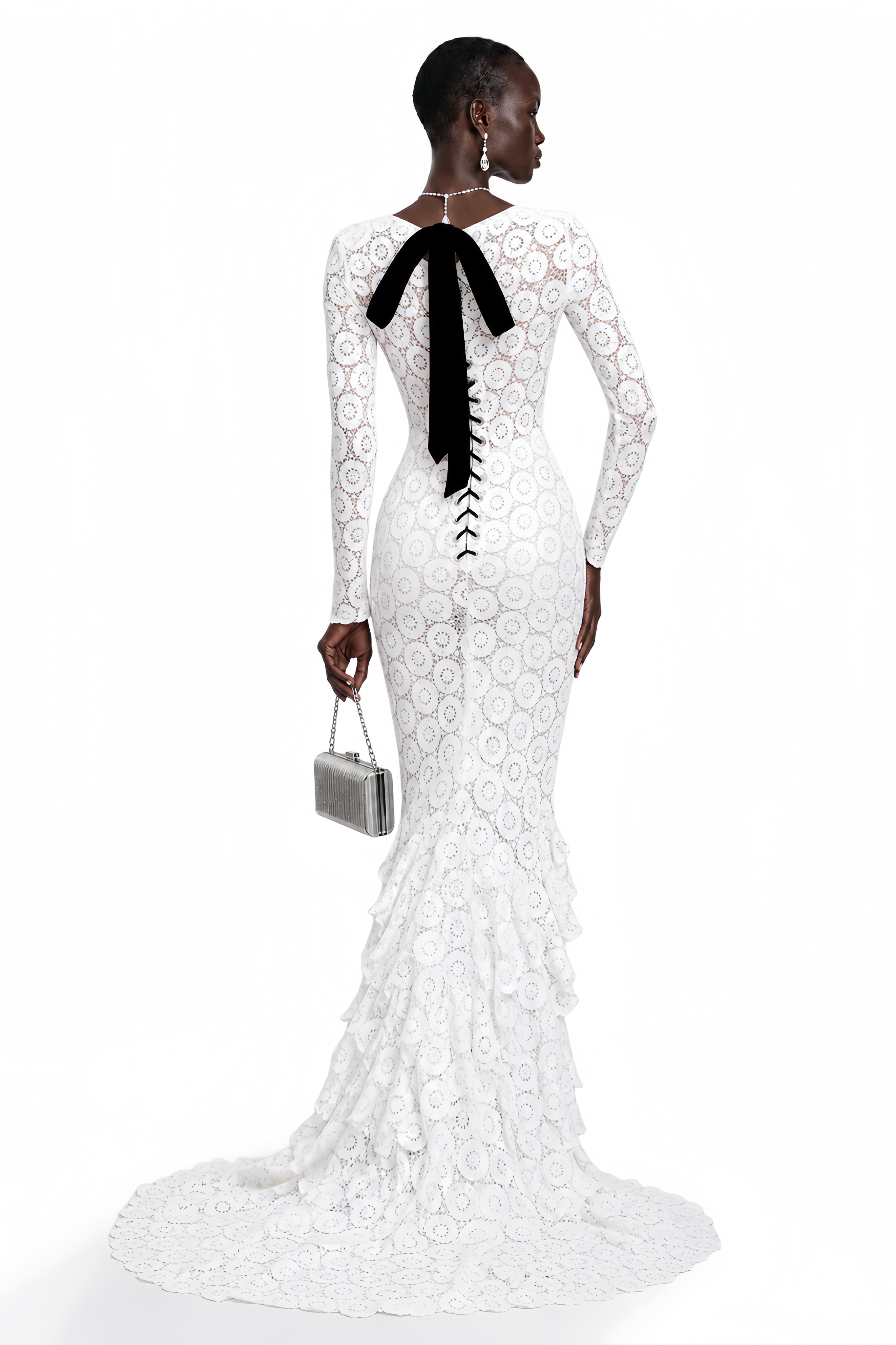 White lace maxi dress with a plunging neckline, cutout with floral detail, and a ruffled tiered train