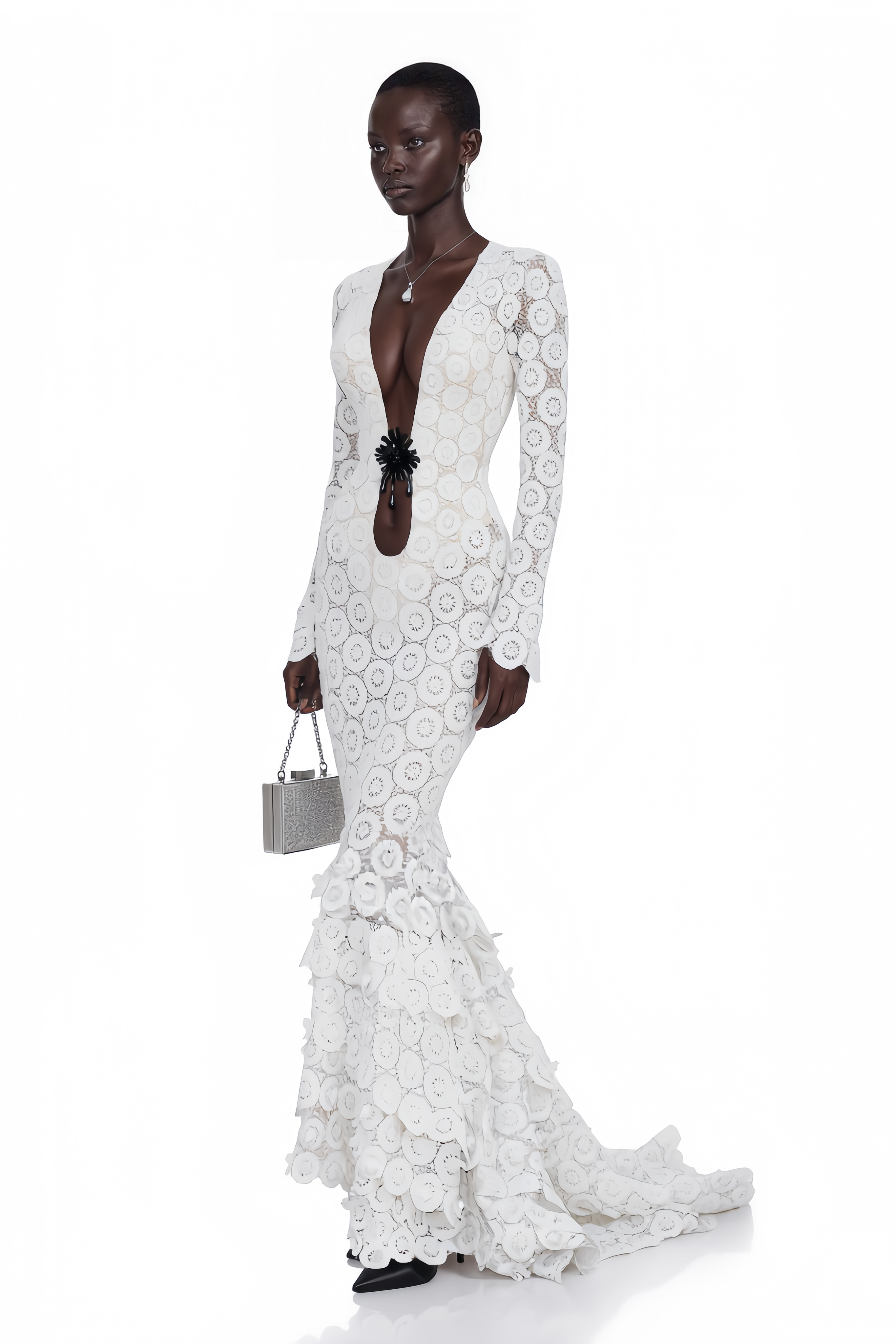 White lace maxi dress with a plunging neckline, cutout with floral detail, and a ruffled tiered train