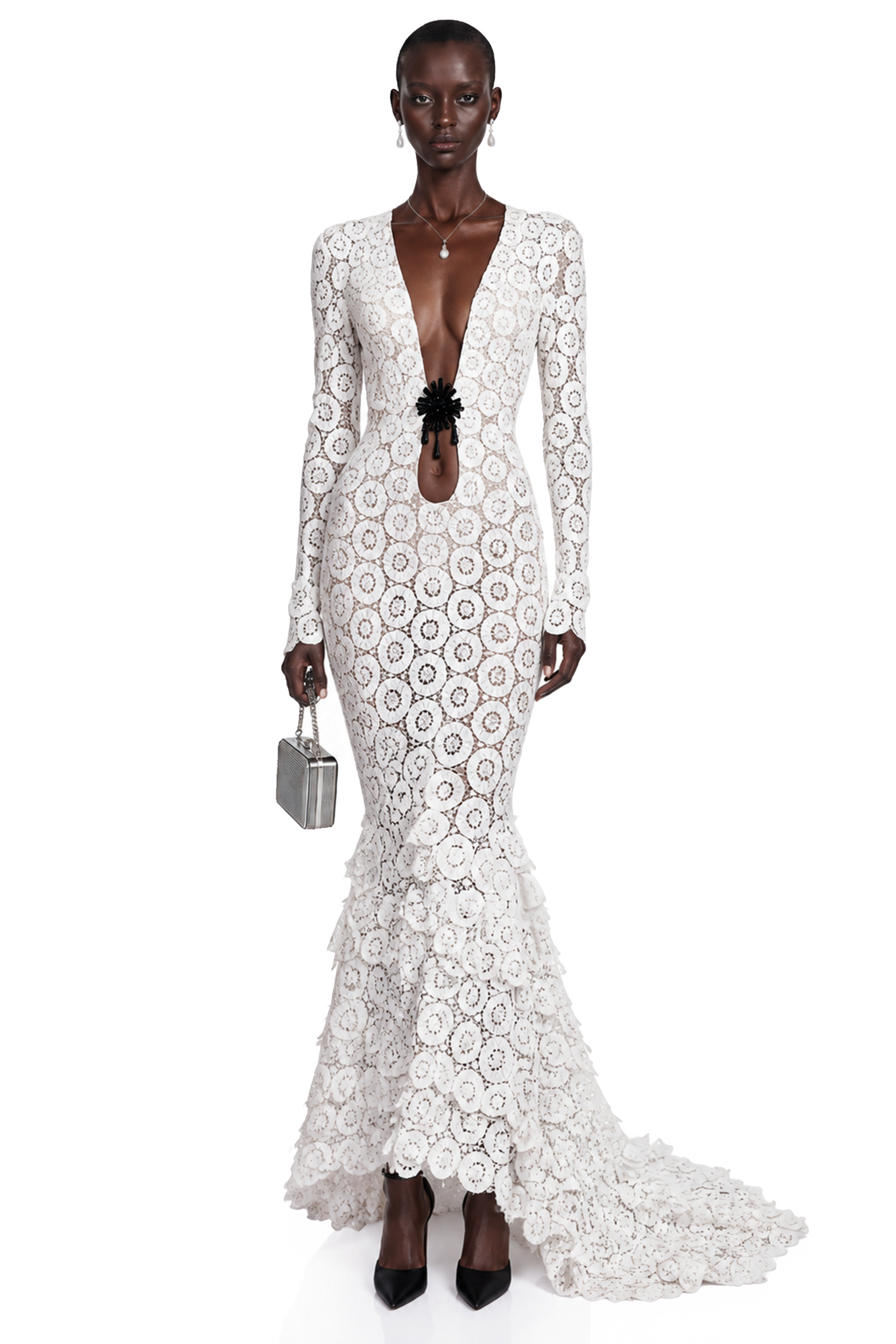 White lace maxi dress with a plunging neckline, cutout with floral detail, and a ruffled tiered train