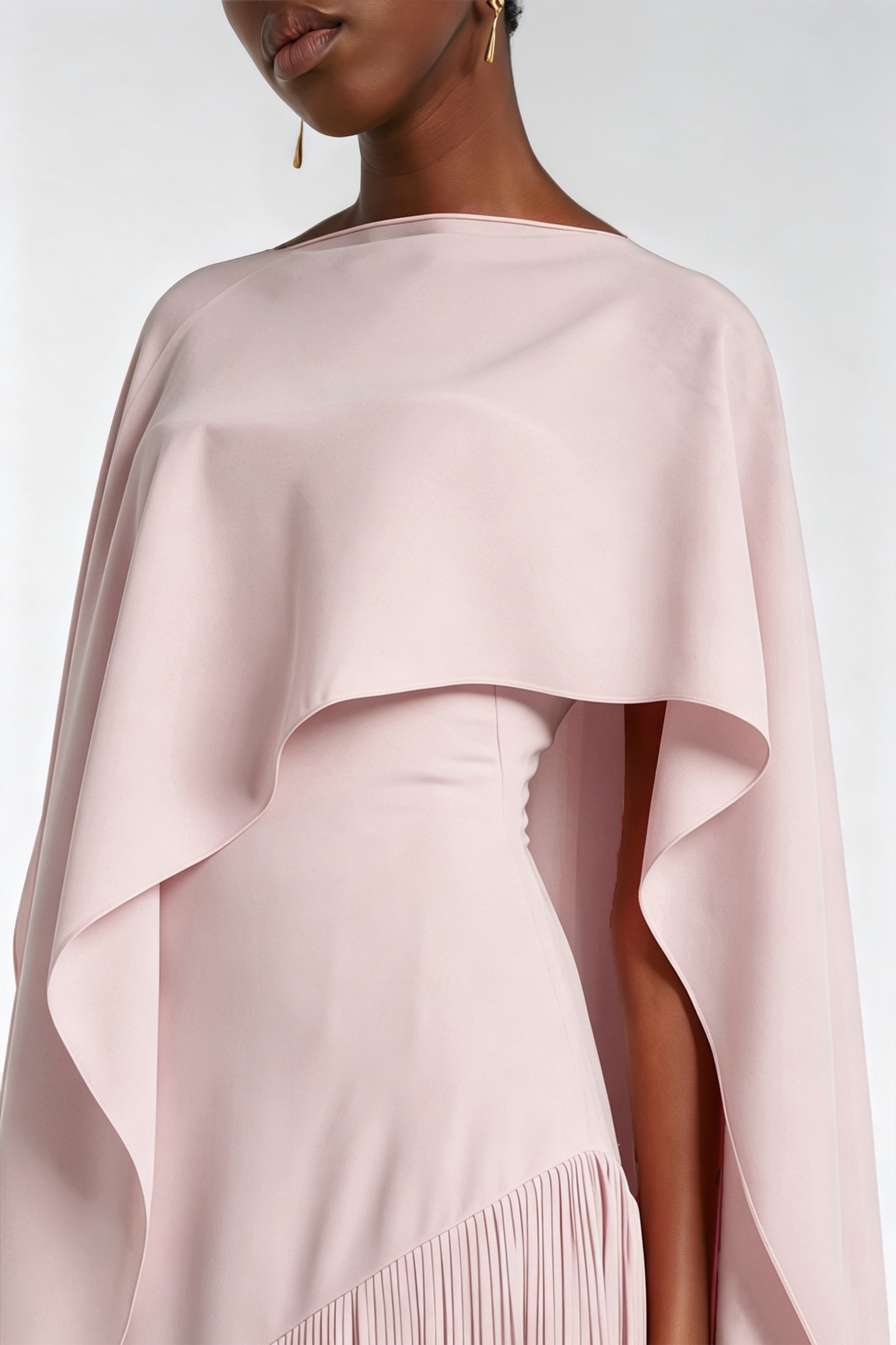 Blush pink maxi dress with a matching overlay cape and a long asymmetric fringe skirt