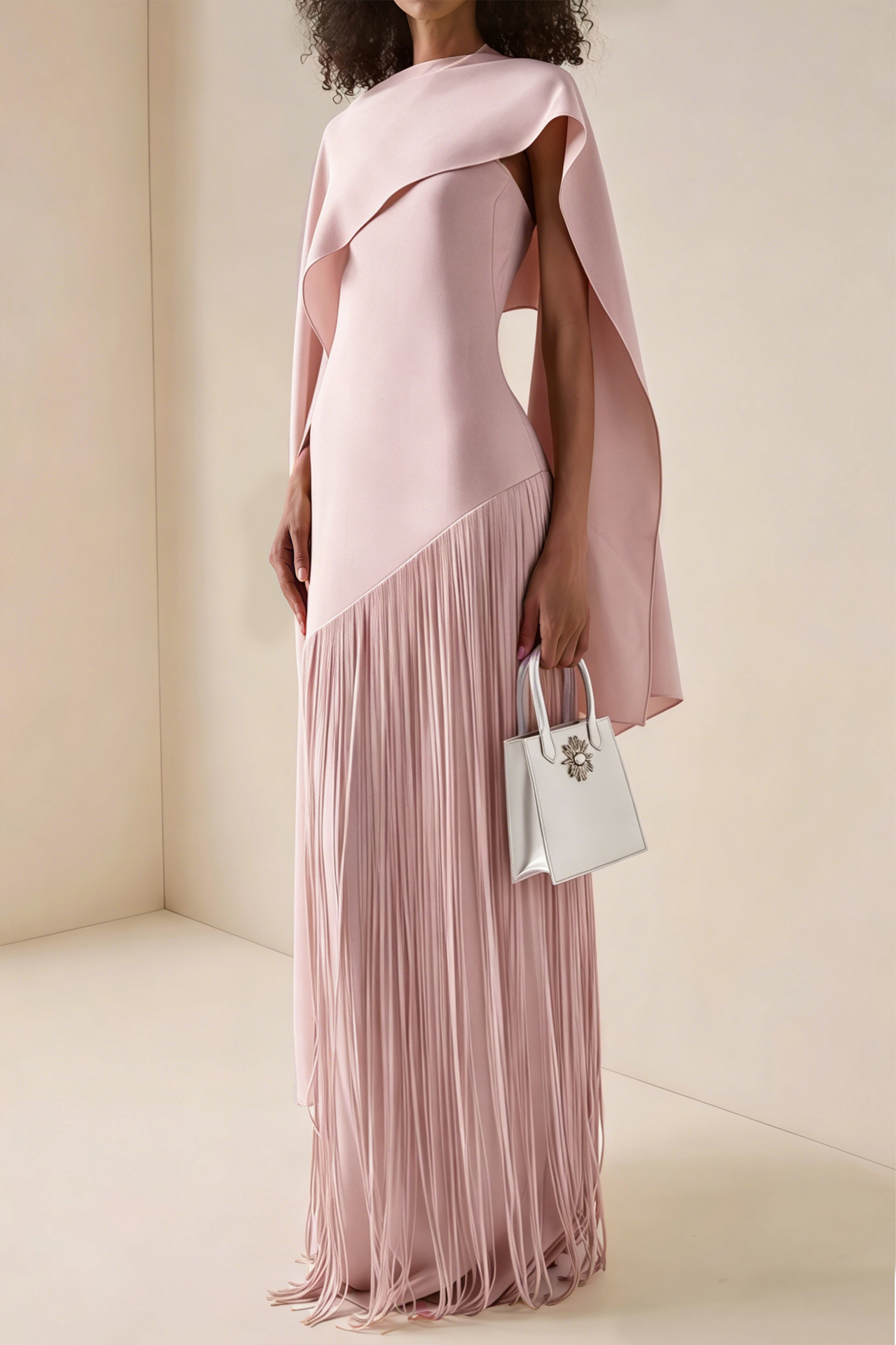Blush pink maxi dress with a matching overlay cape and a long asymmetric fringe skirt
