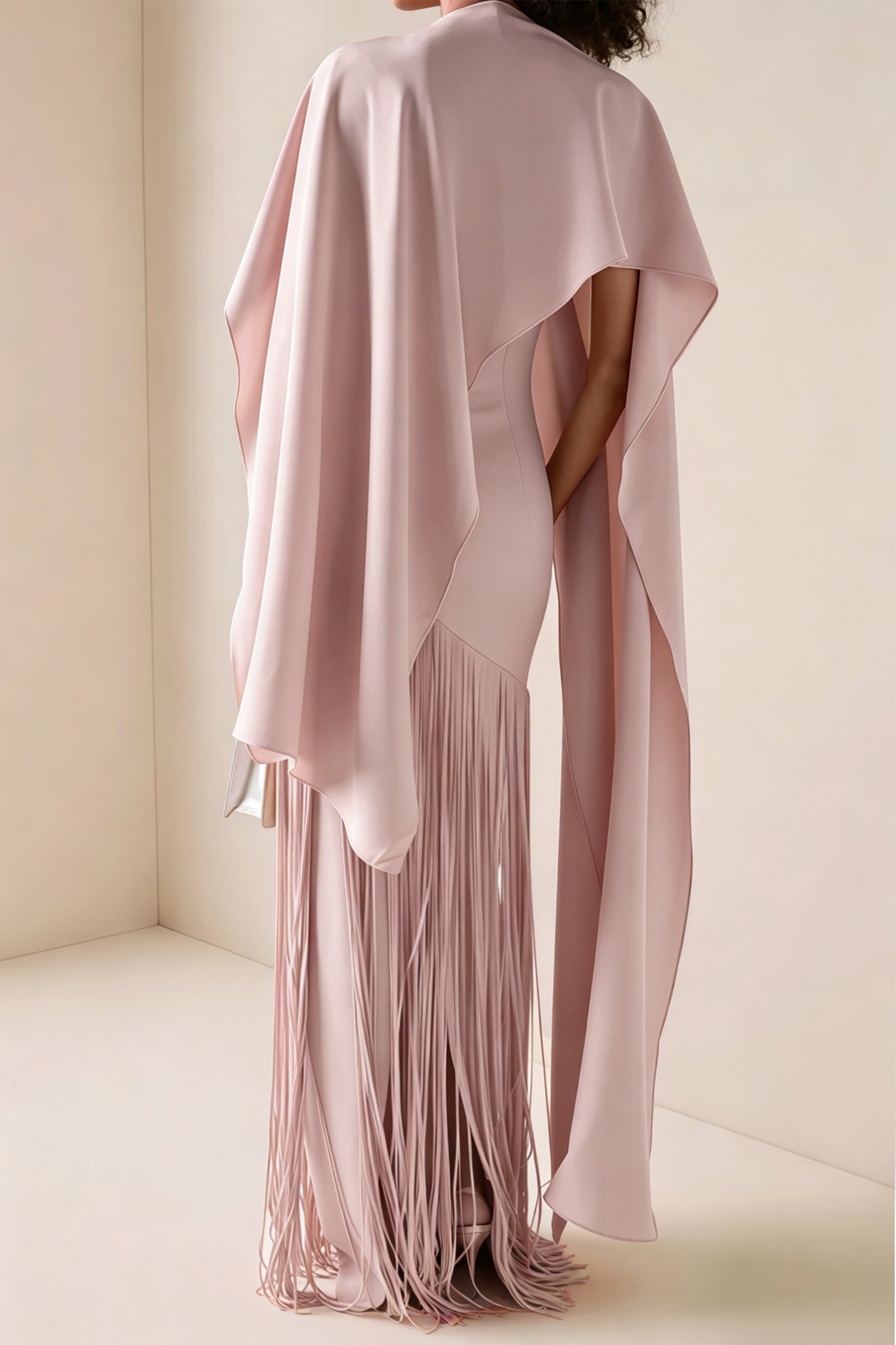 Blush pink maxi dress with a matching overlay cape and a long asymmetric fringe skirt
