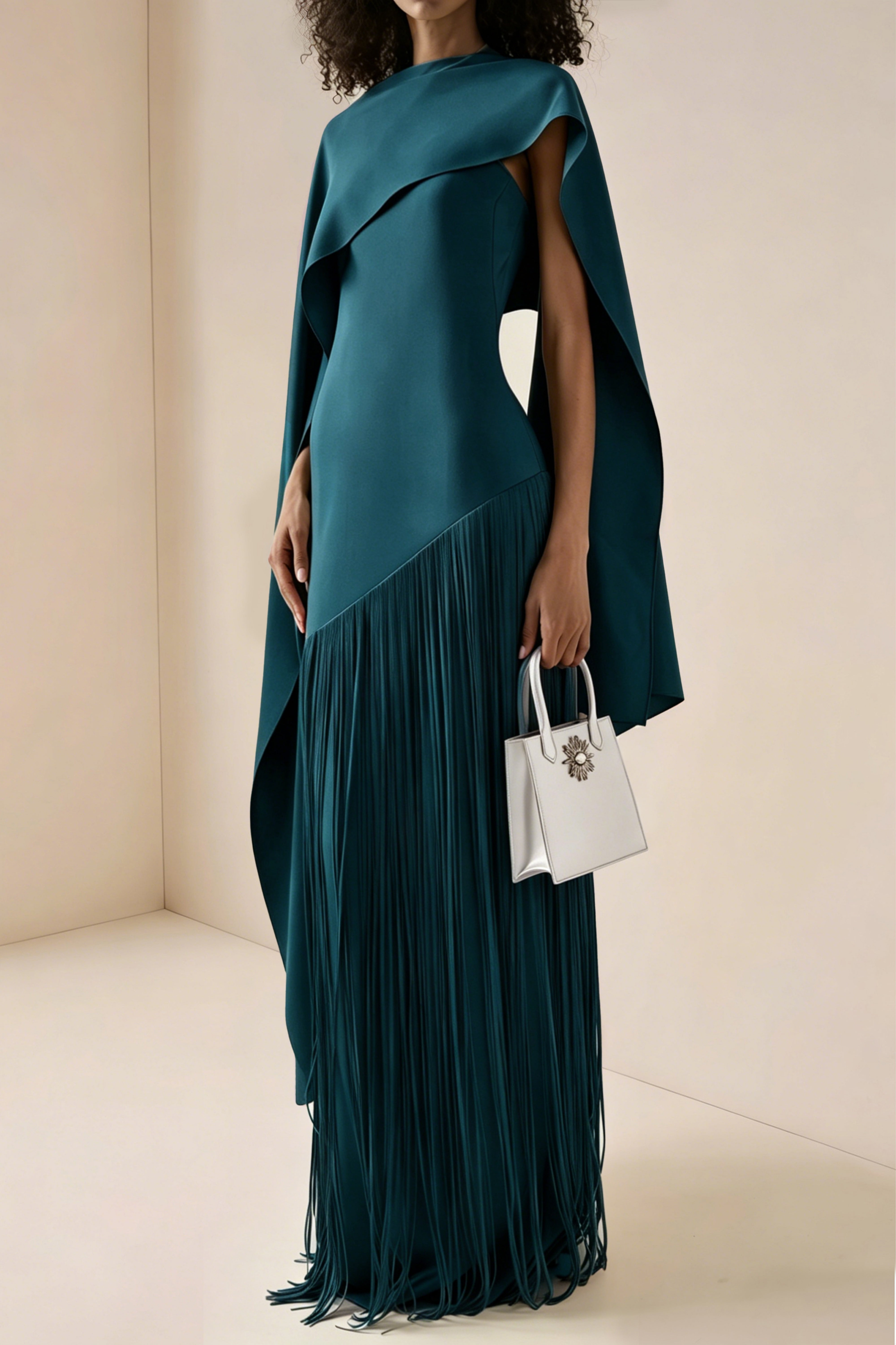 Teal blue maxi dress with a matching overlay cape and a long asymmetric fringe skirt
