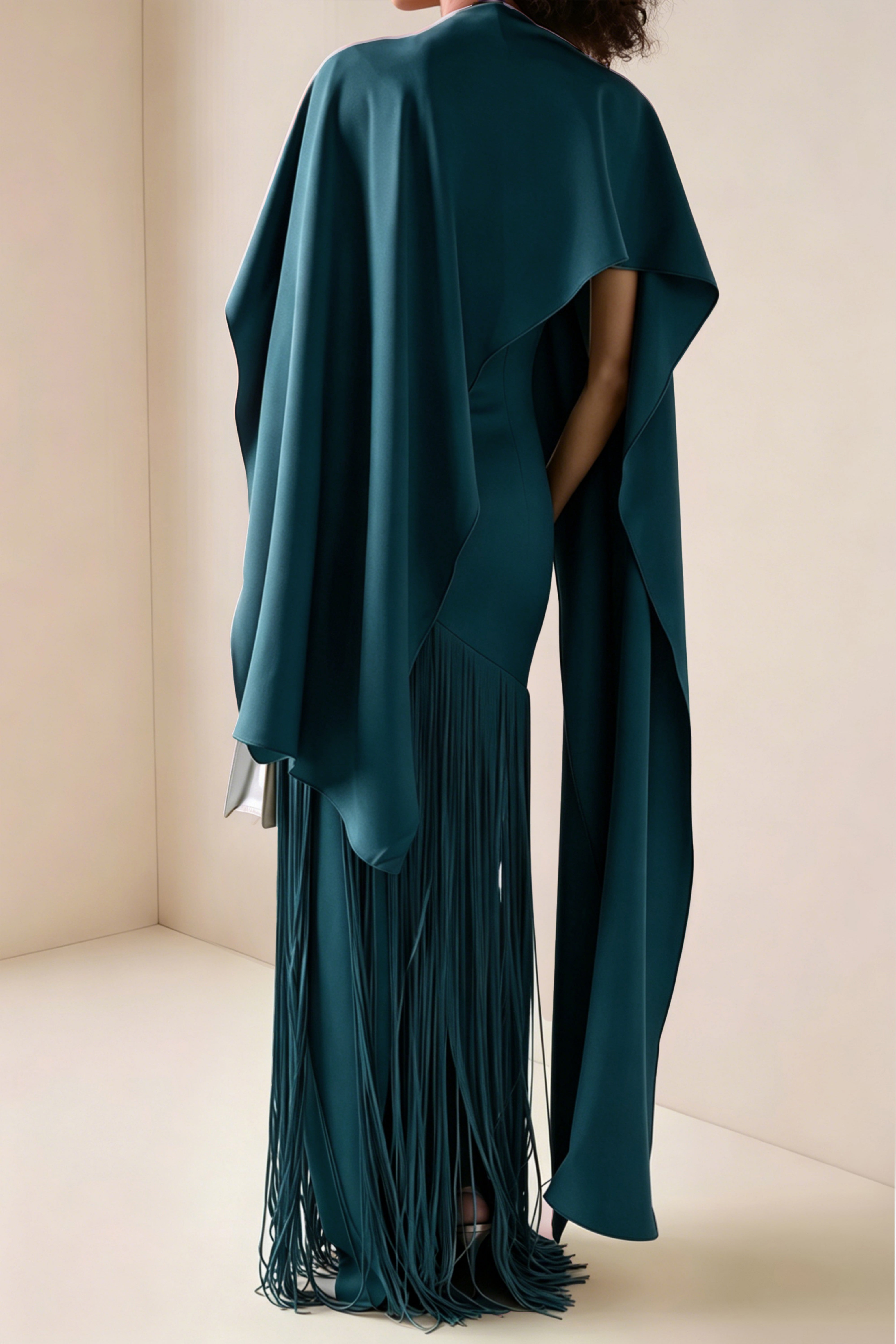 Teal blue maxi dress with a matching overlay cape and a long asymmetric fringe skirt