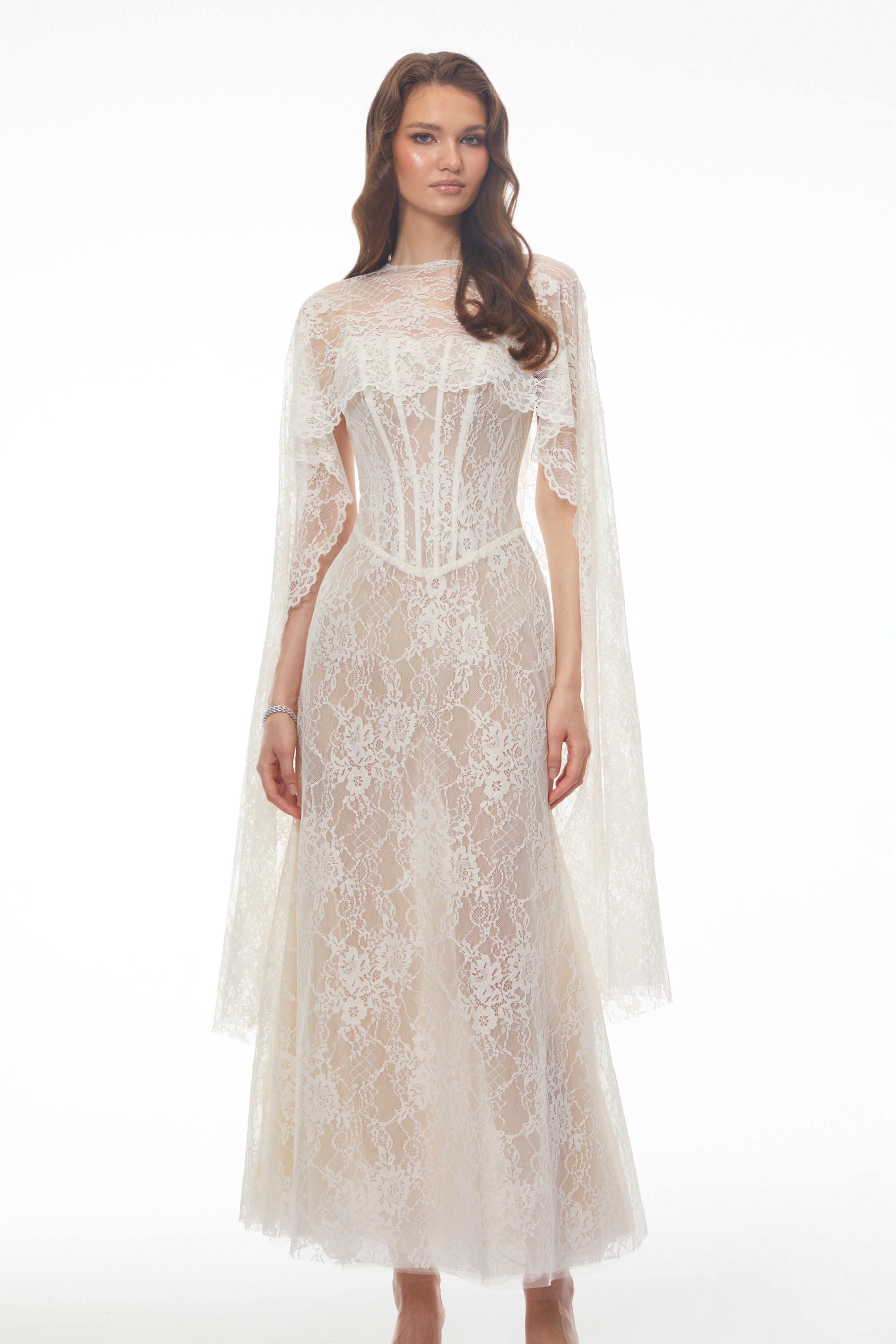 White lace maxi dress with a corset bodice, high neckline, and long draped cape sleeves