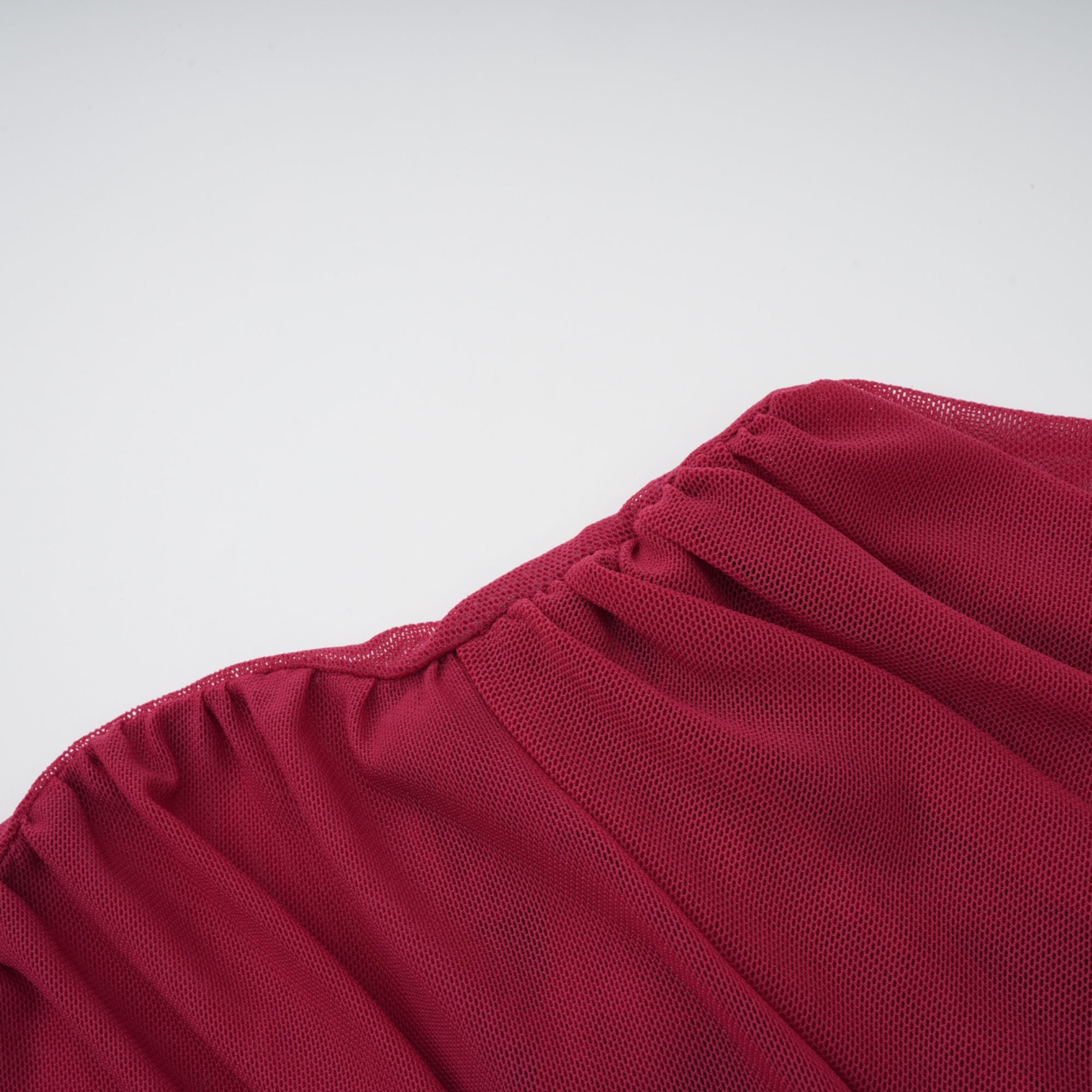 Burgundy ruched gown with a draped high neckline and sheer skirt