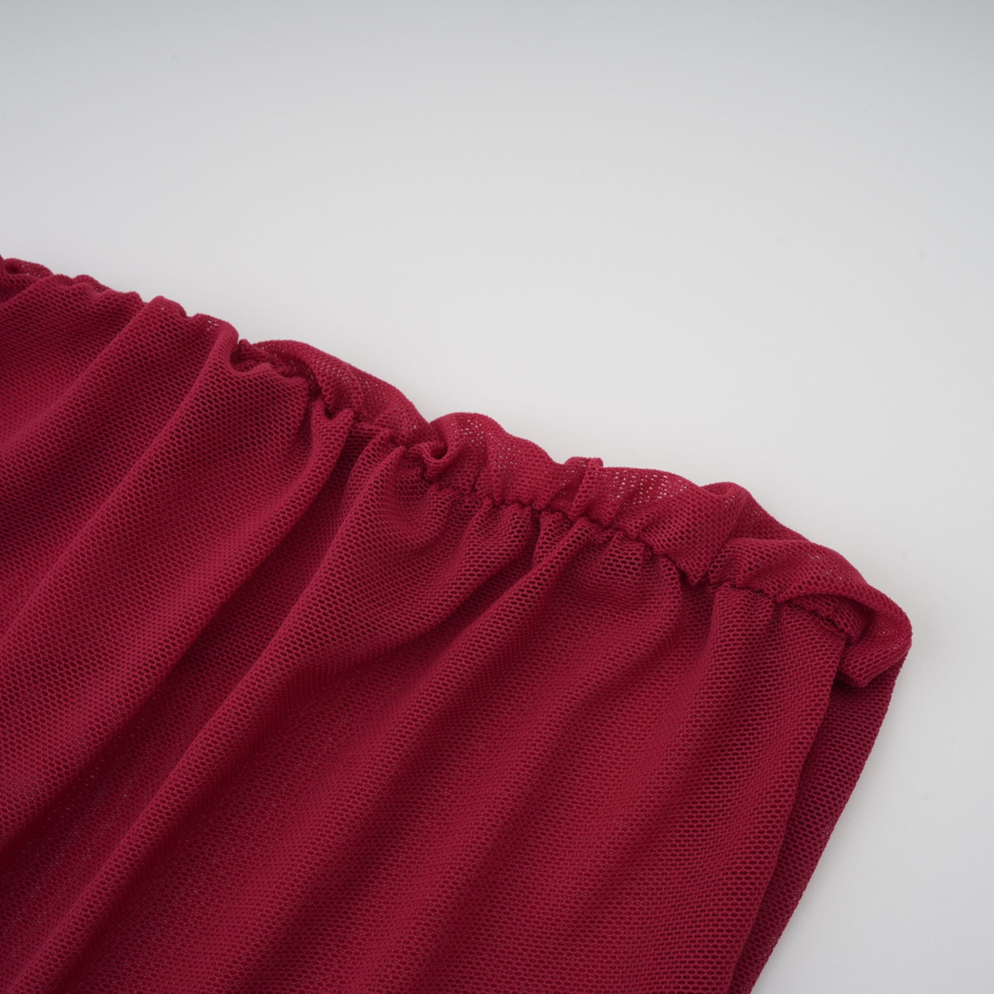 Burgundy ruched gown with a draped high neckline and sheer skirt
