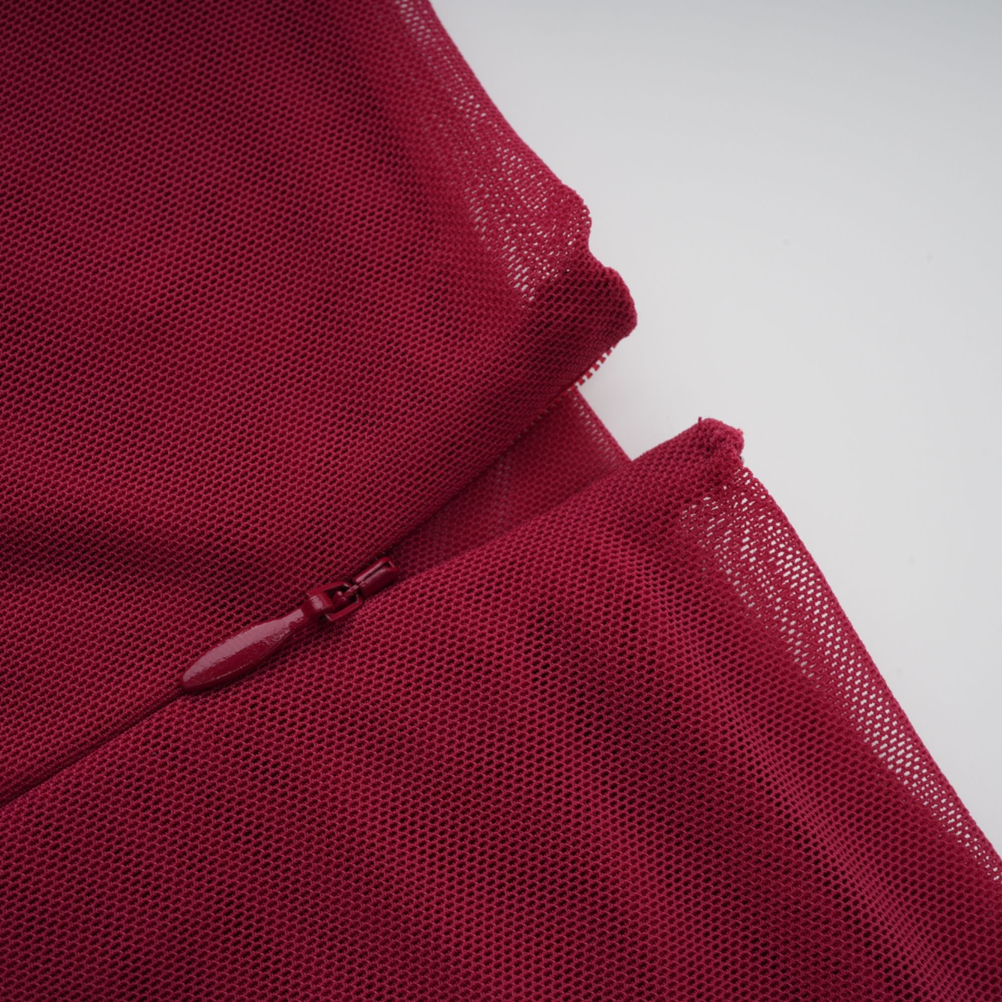 Burgundy ruched gown with a draped high neckline and sheer skirt