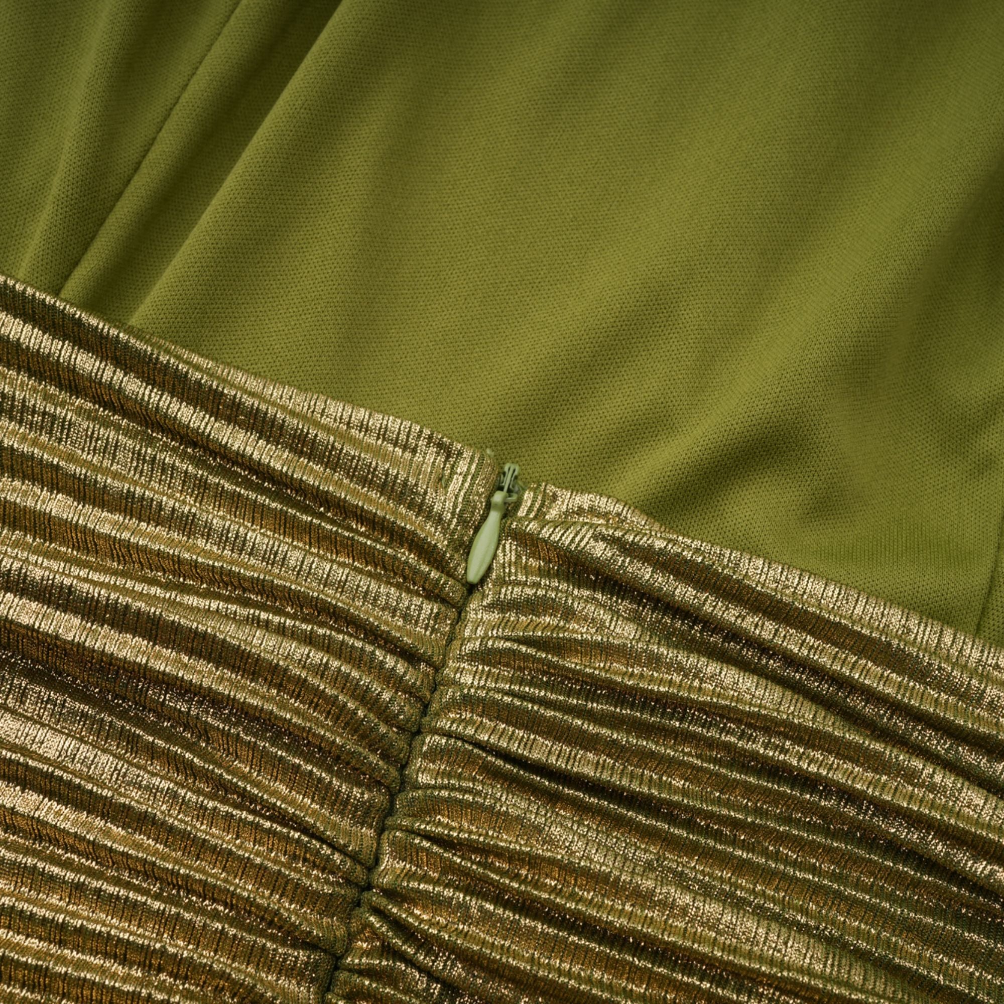Olive green metallic halter gown with a pleated skirt and high slit