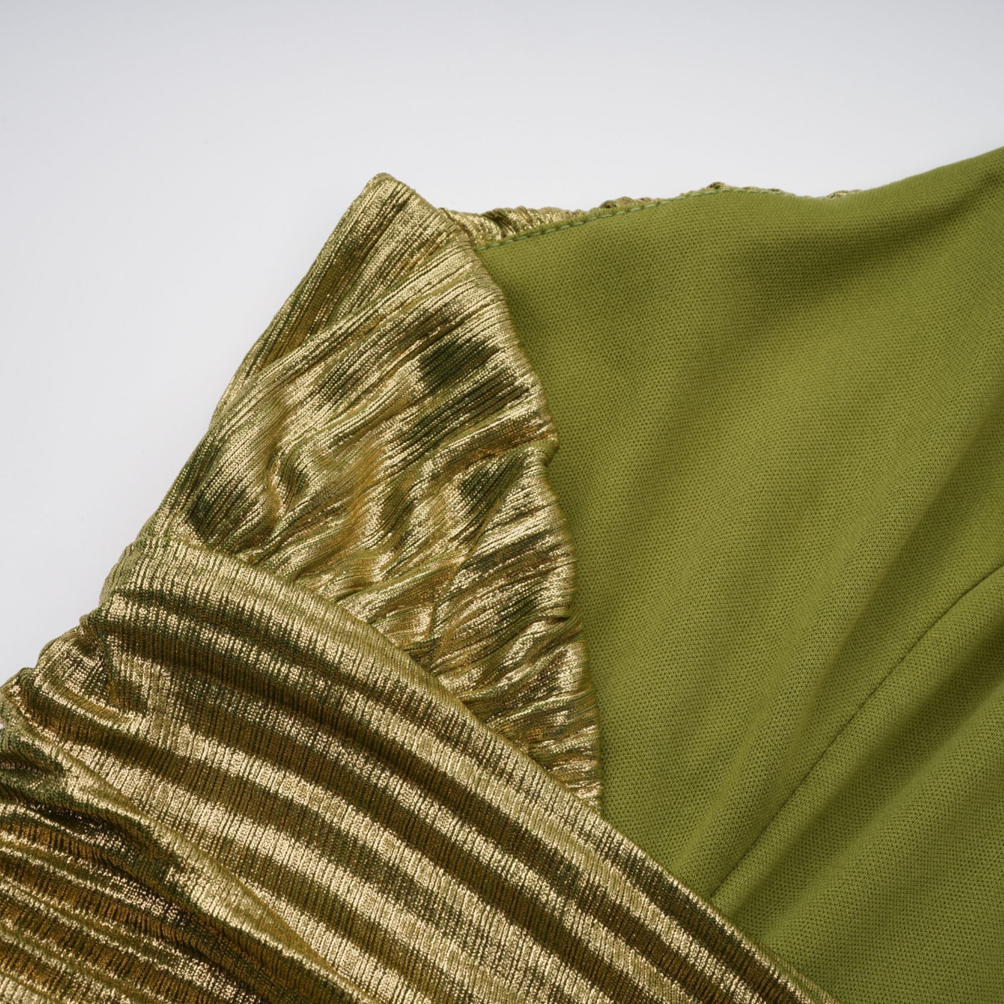 Olive green metallic halter gown with a pleated skirt and high slit