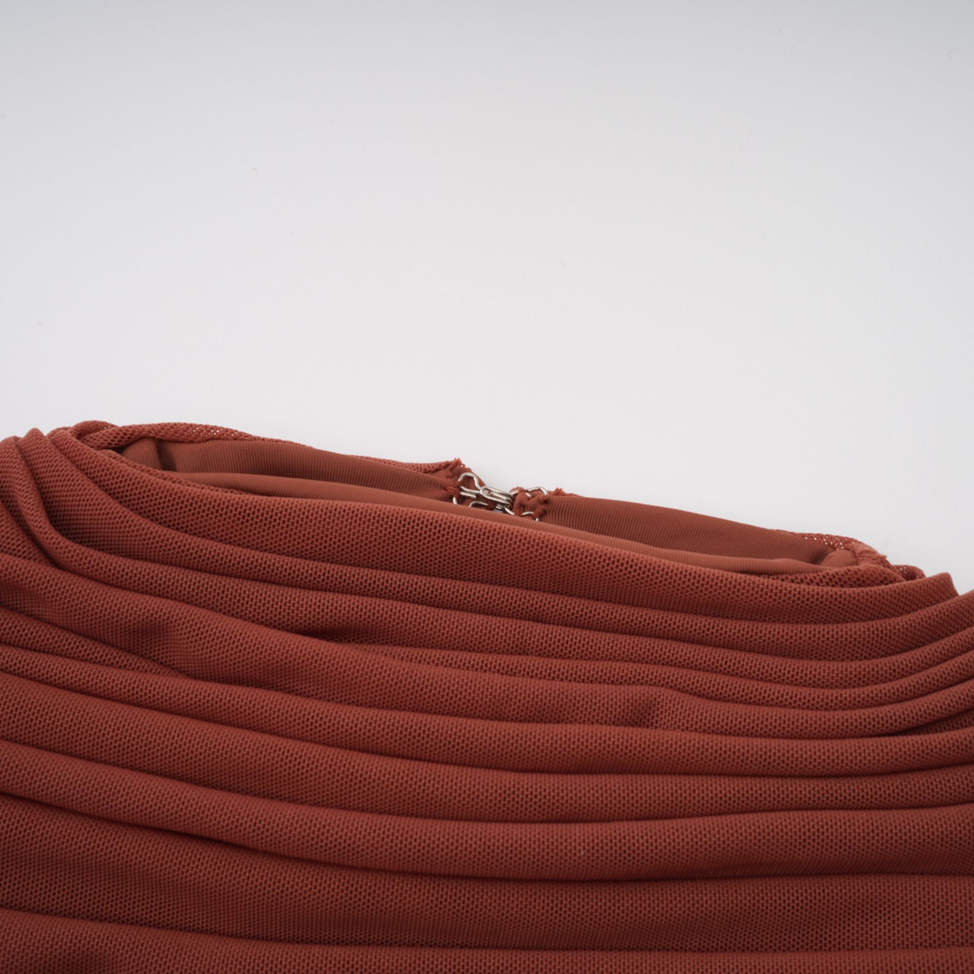 Rust-colored long-sleeve maxi dress with a draped cowl neckline and pleated bodice