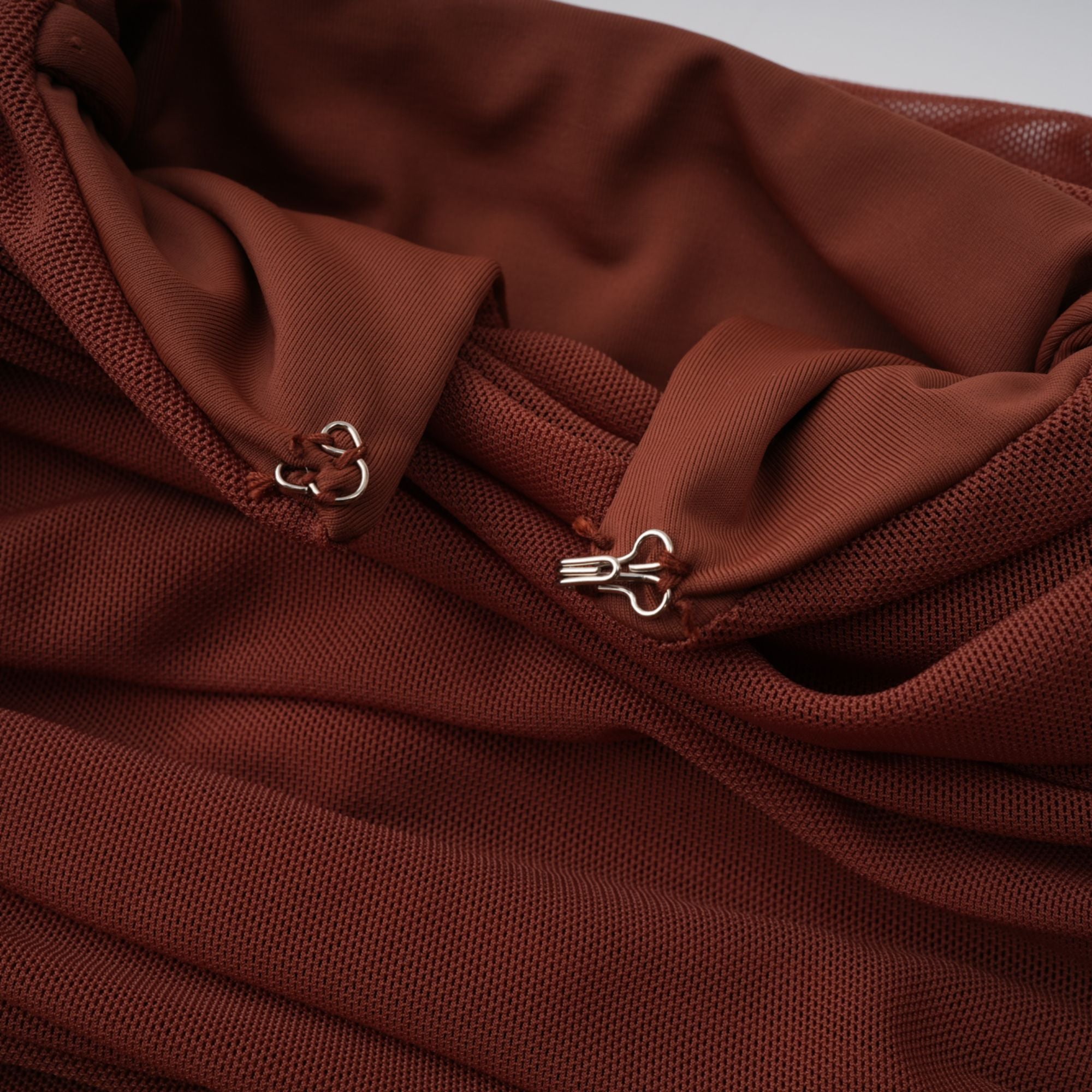 Rust-colored long-sleeve maxi dress with a draped cowl neckline and pleated bodice