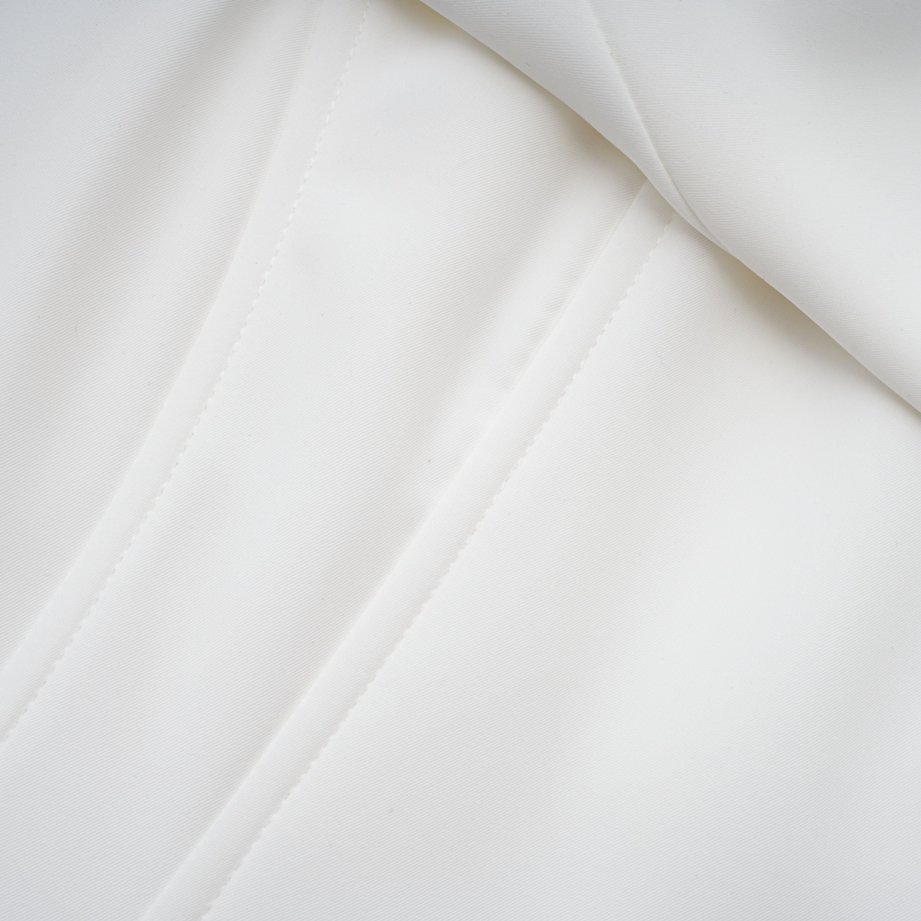 White off-the-shoulder gown with a draped bodice and cascading side ruffles
