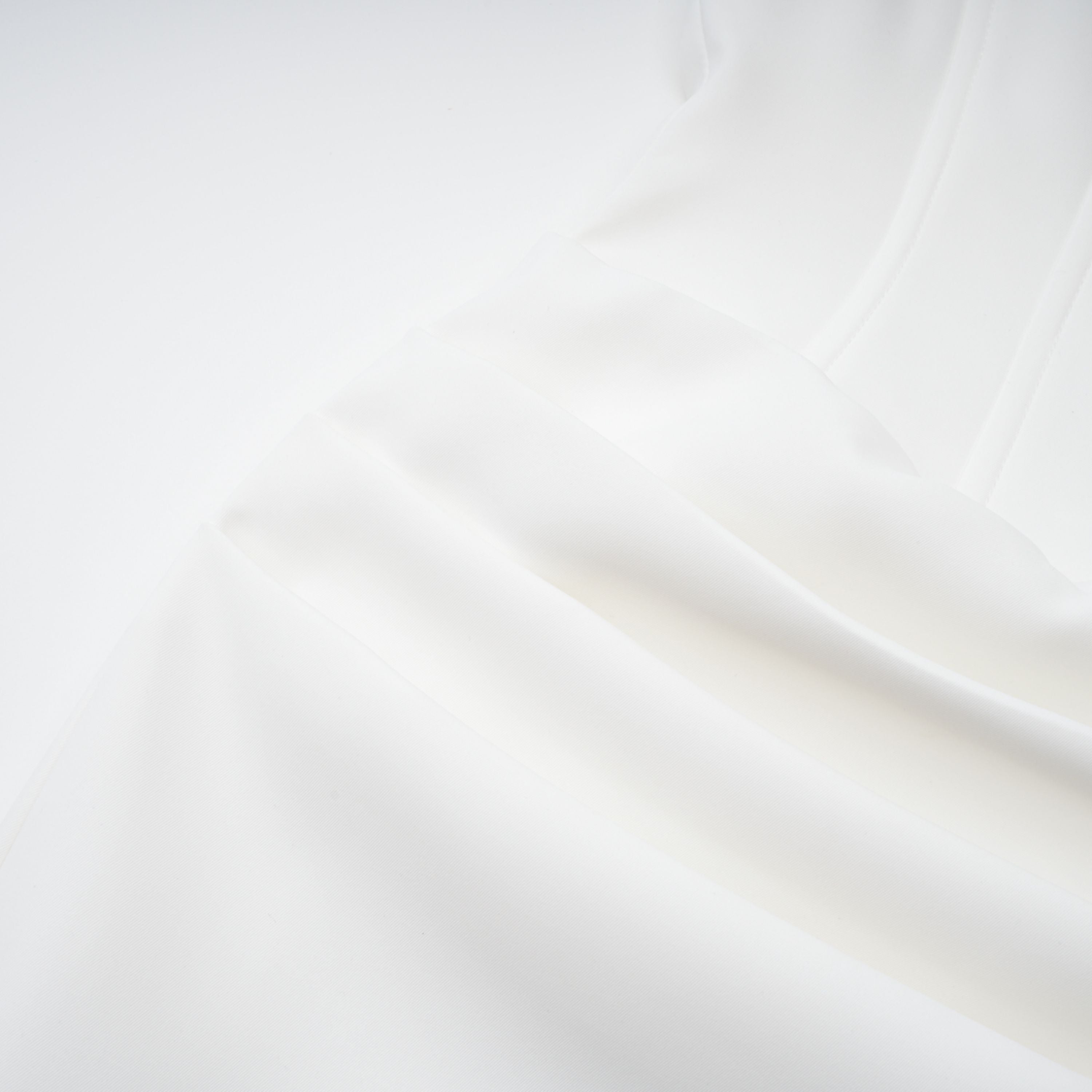 White off-the-shoulder gown with a draped bodice and cascading side ruffles