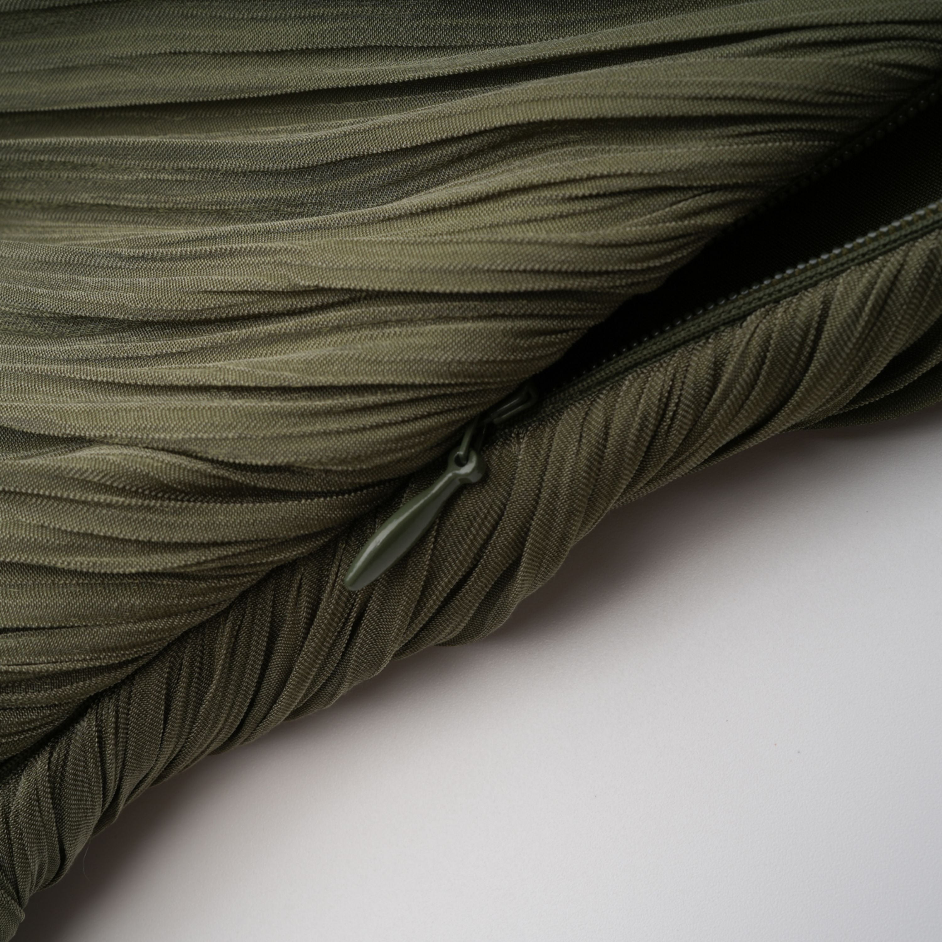 Olive green pleated one-shoulder gown with beaded embellishments and a long draped shoulder cape