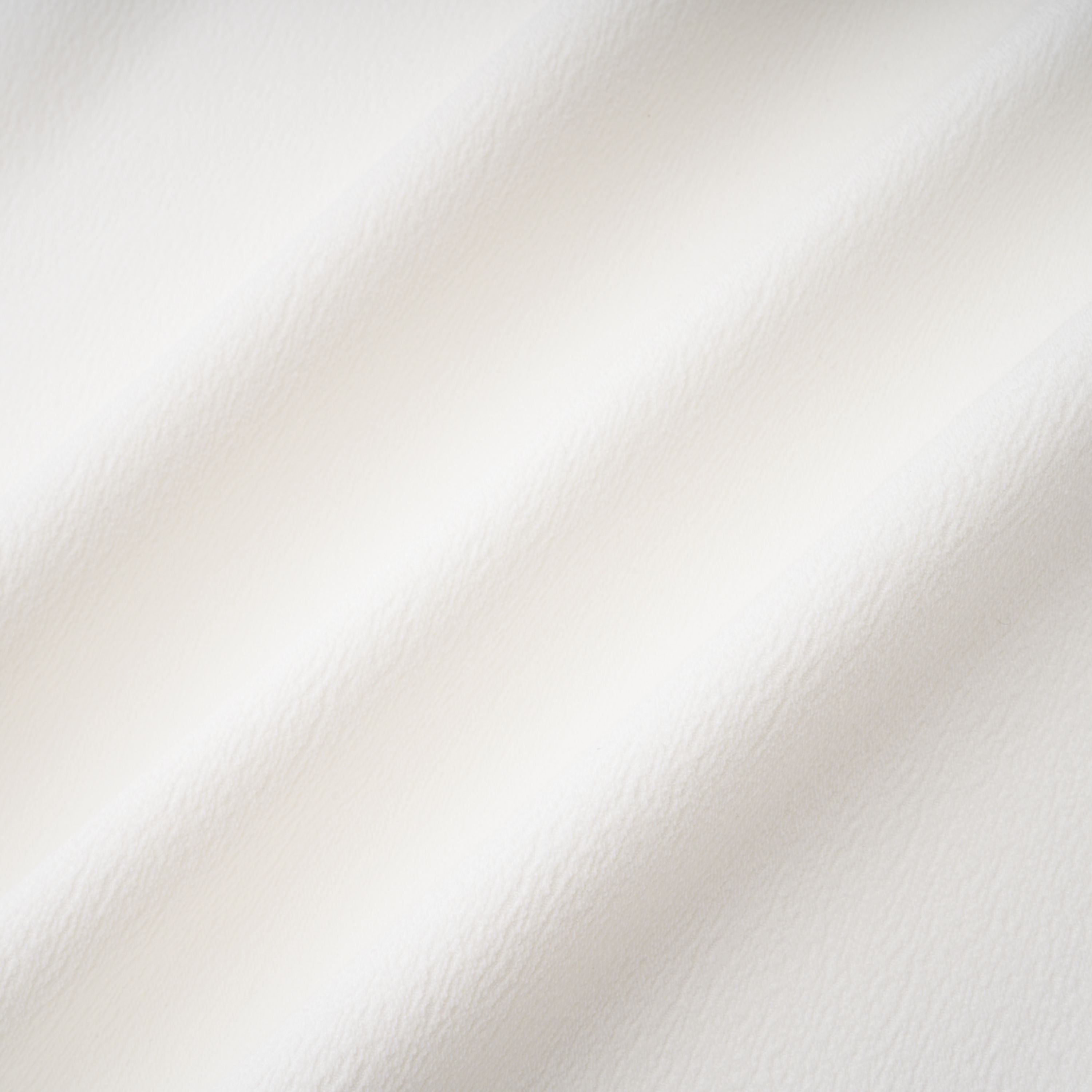White sleeveless midi dress featuring a high drape neck with a brooch detail and a structured asymmetric handkerchief skirt
