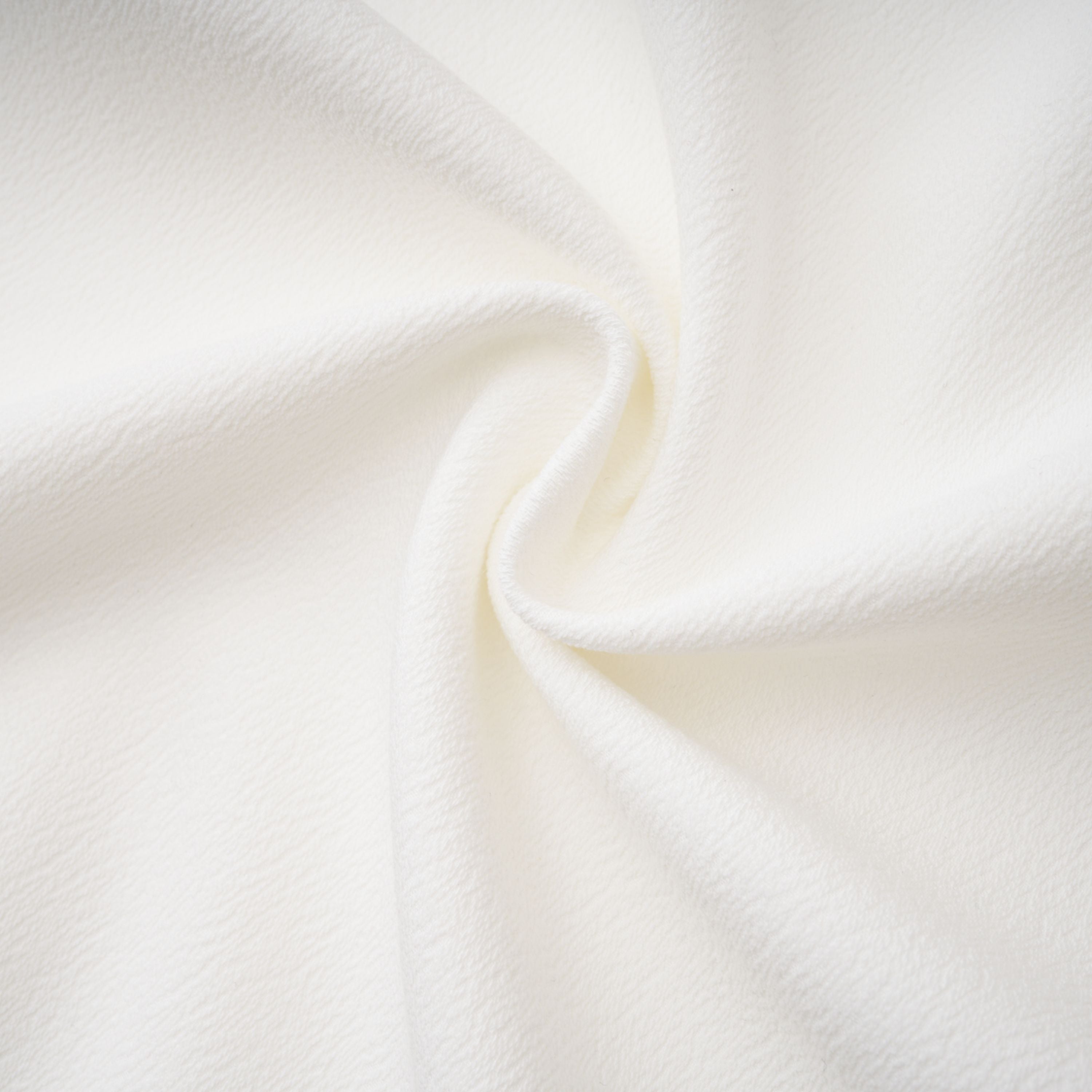 White sleeveless midi dress featuring a high drape neck with a brooch detail and a structured asymmetric handkerchief skirt