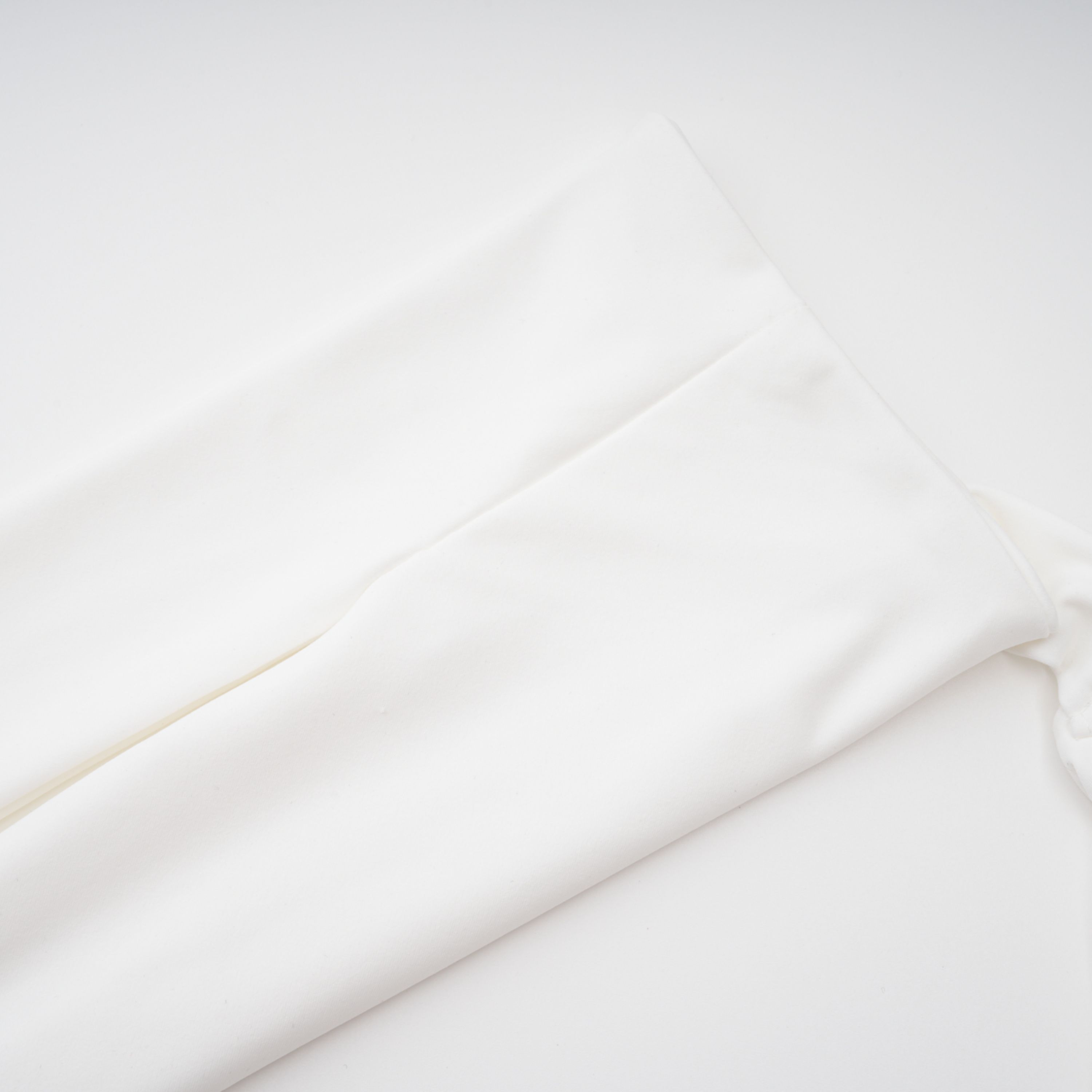 White halter-neck maxi dress with a draped panel skirt and high leg cutouts