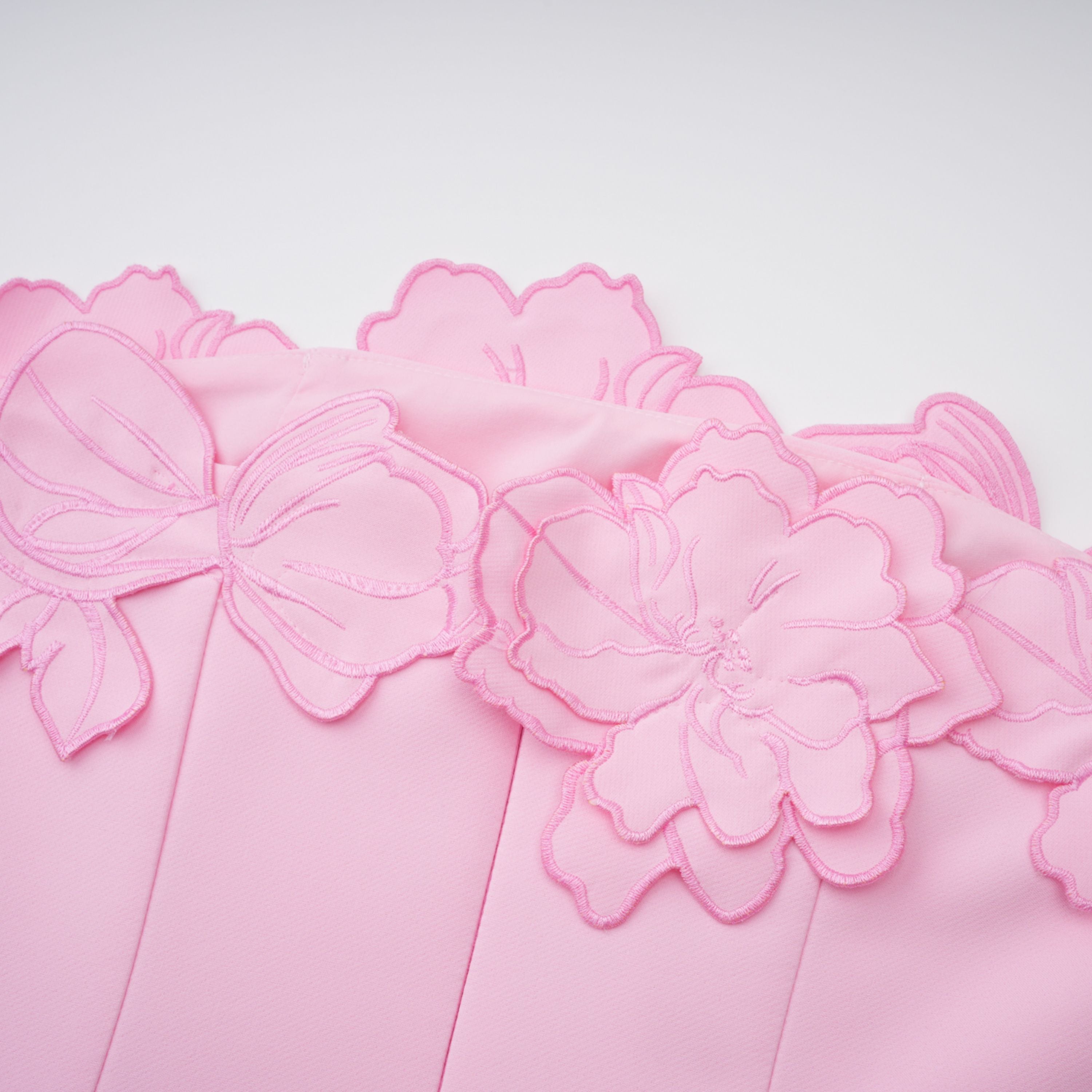 Pink strapless midi dress with a cutout floral hem