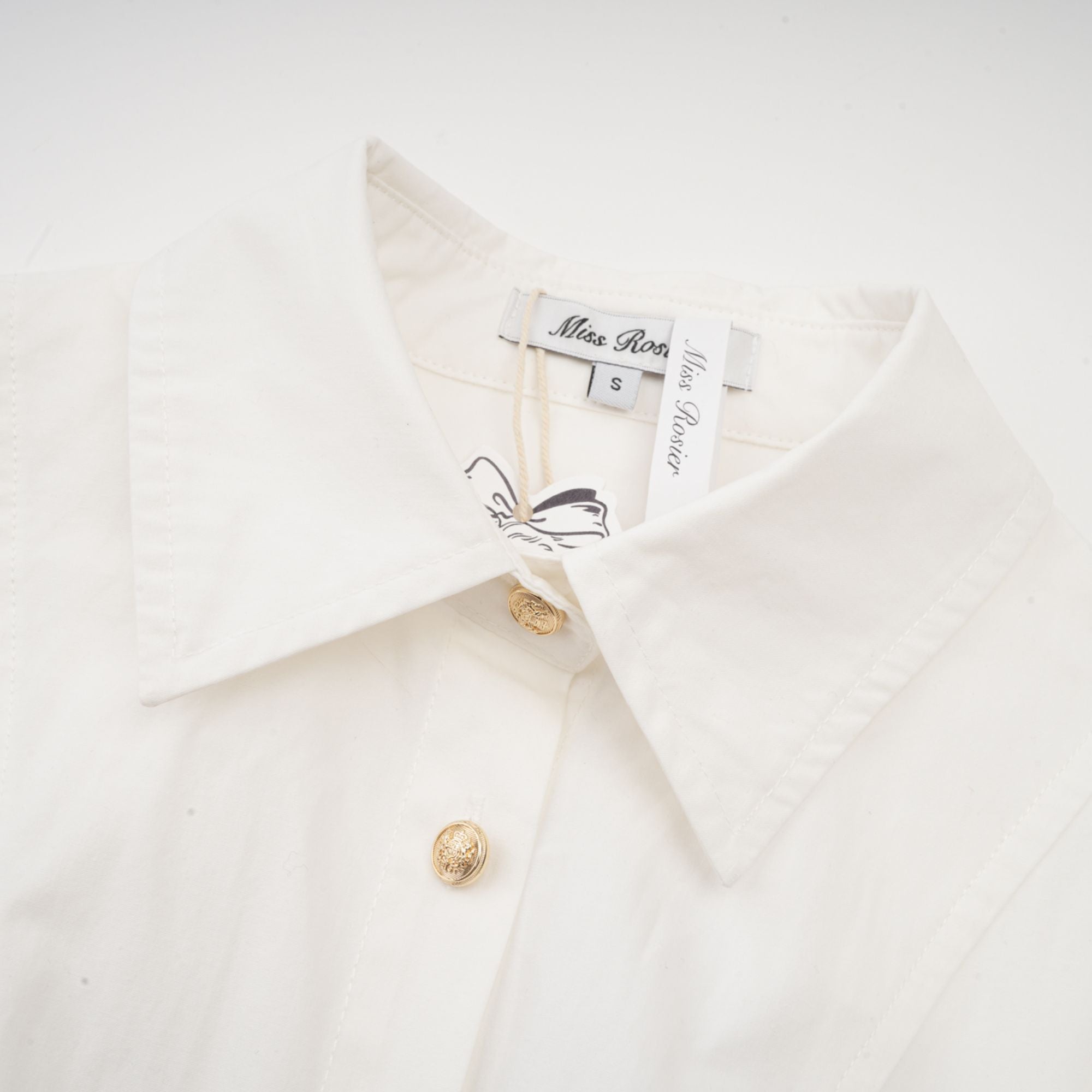 White long-sleeve corset shirt dress with a draped mini skirt
