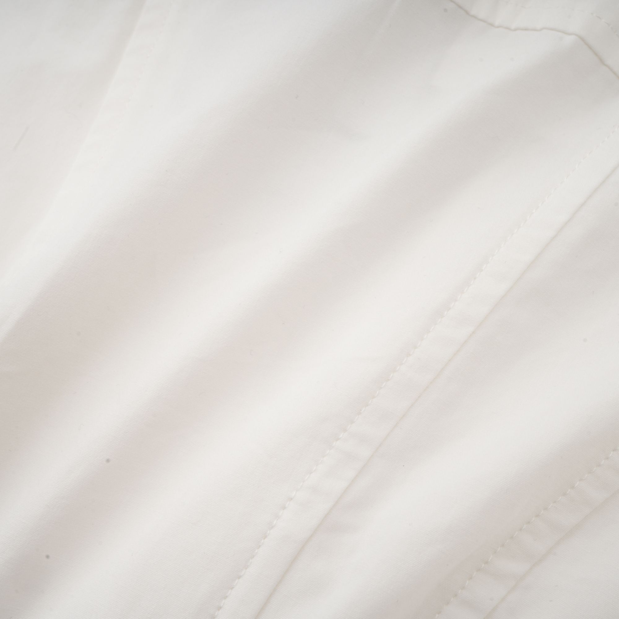 White long-sleeve corset shirt dress with a draped mini skirt
