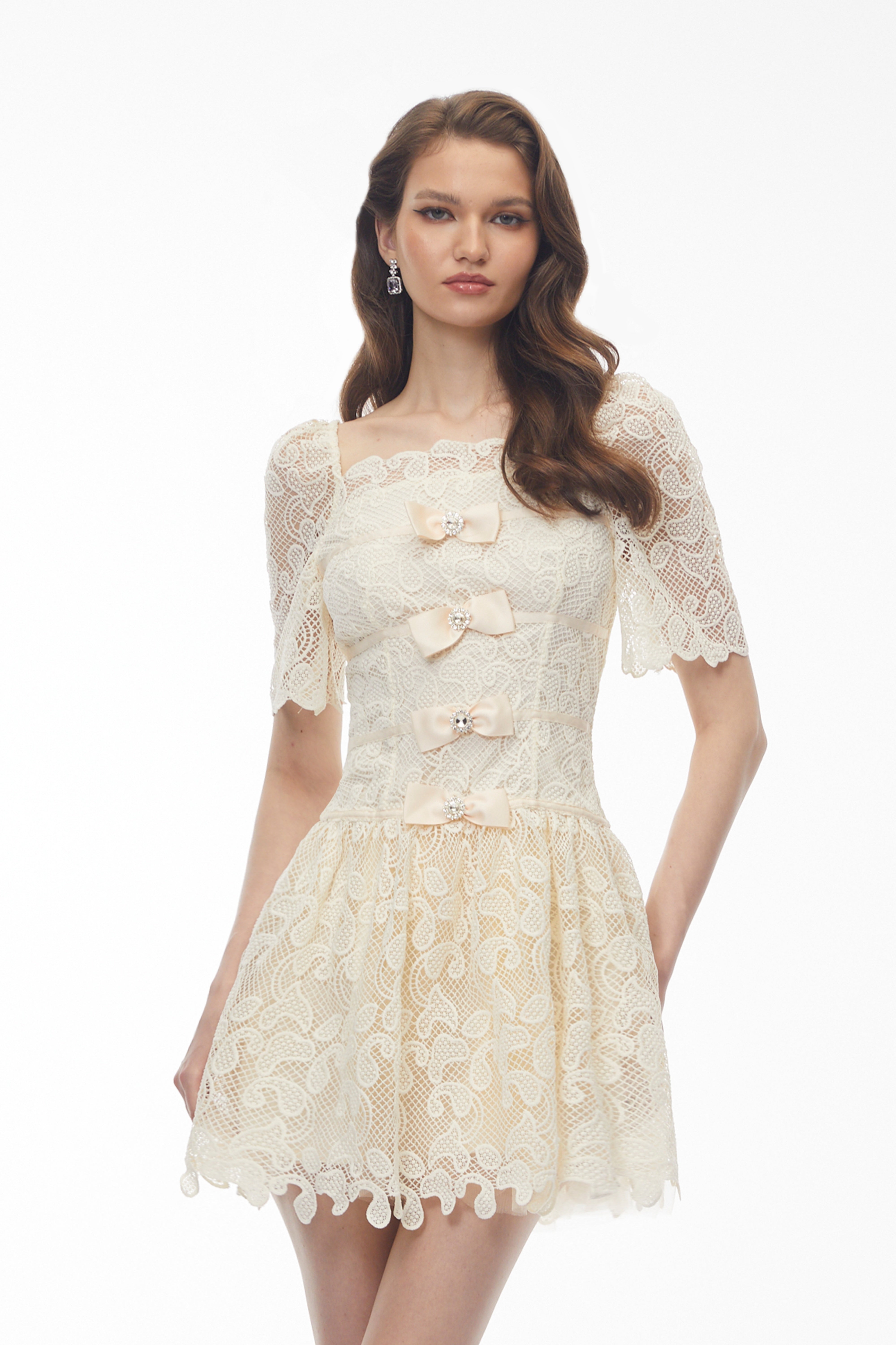 Cream lace mini dress with bow accents and crystal details